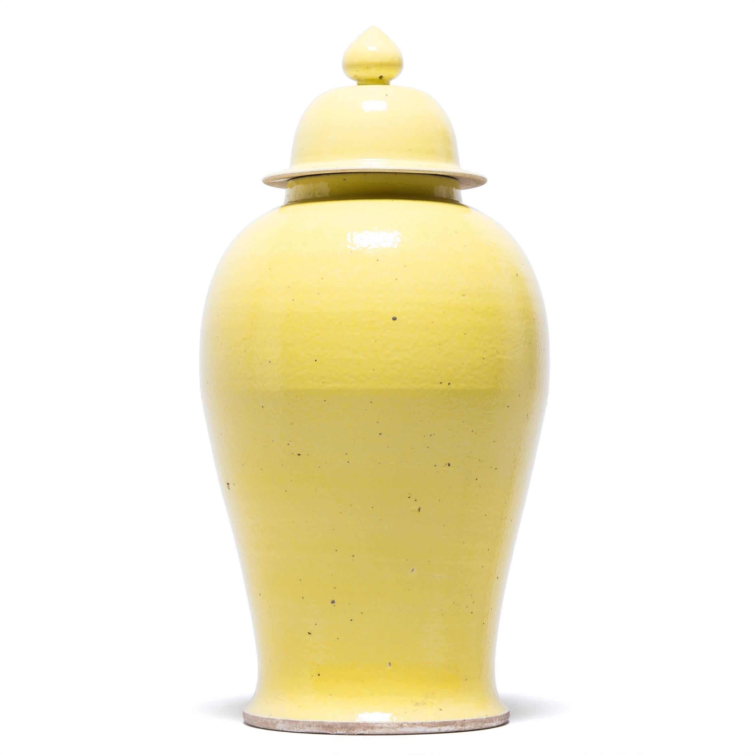 This contemporary take on the traditional baluster jar puts all the focus on its timeless silhouette. Characterized by its high shoulders, flared base and domed lid, the elegant baluster jar form is accentuated here with a cheerful, citron-yellow