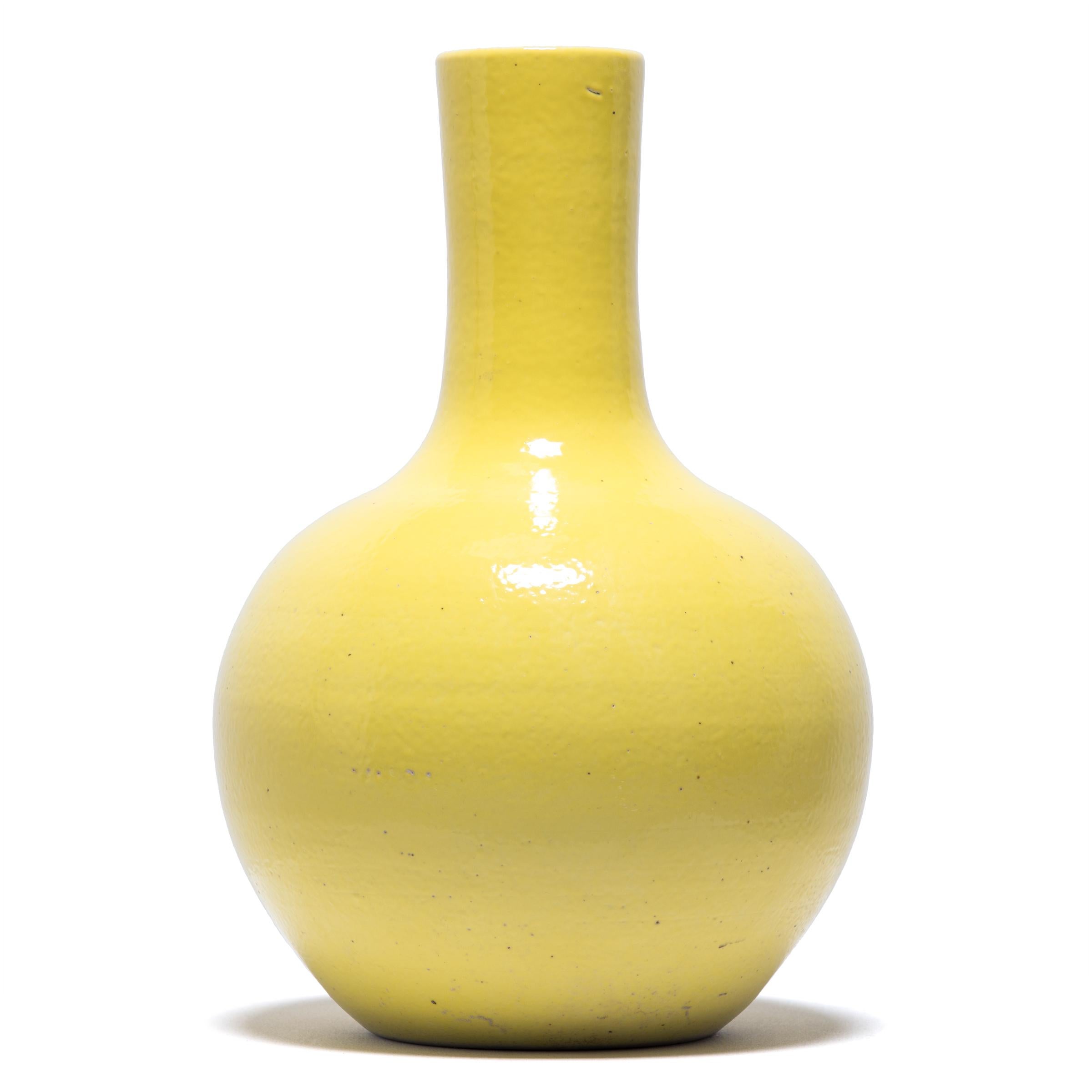 S'inspirant d'une longue tradition chinoise de céramiques monochromes, ce grand vase à col de cygne est recouvert d'une vibrante glaçure jaune citron. Le vase se caractérise par un corps arrondi et globulaire et un col cylindrique étroit, une forme