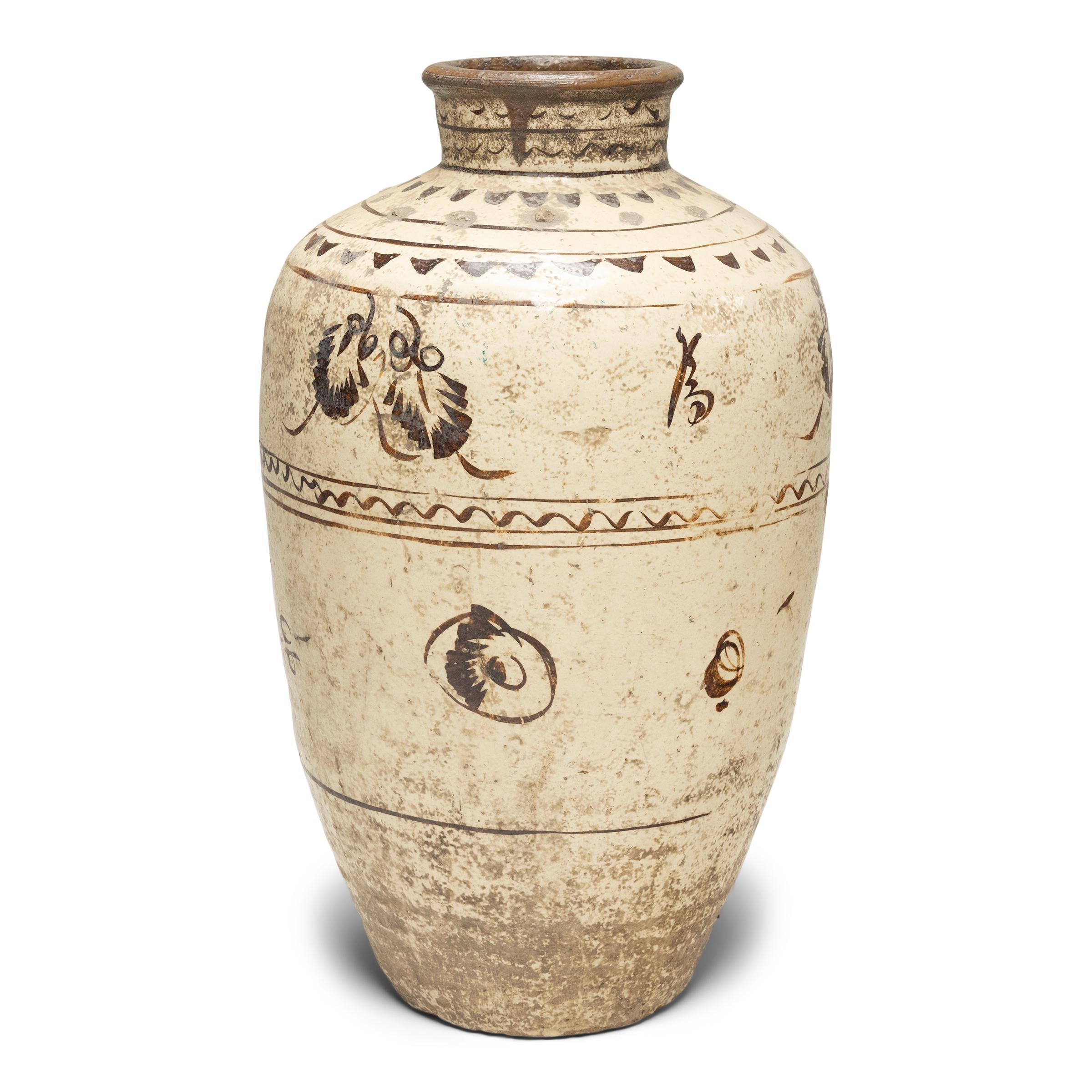 This impressive glazed vessel dates to the mid-19th century and was used to store wine and spirits made from rice and other grains. The large jar has an elegant, tapered form and is beautifully glazed with neutral earth-tones in a style