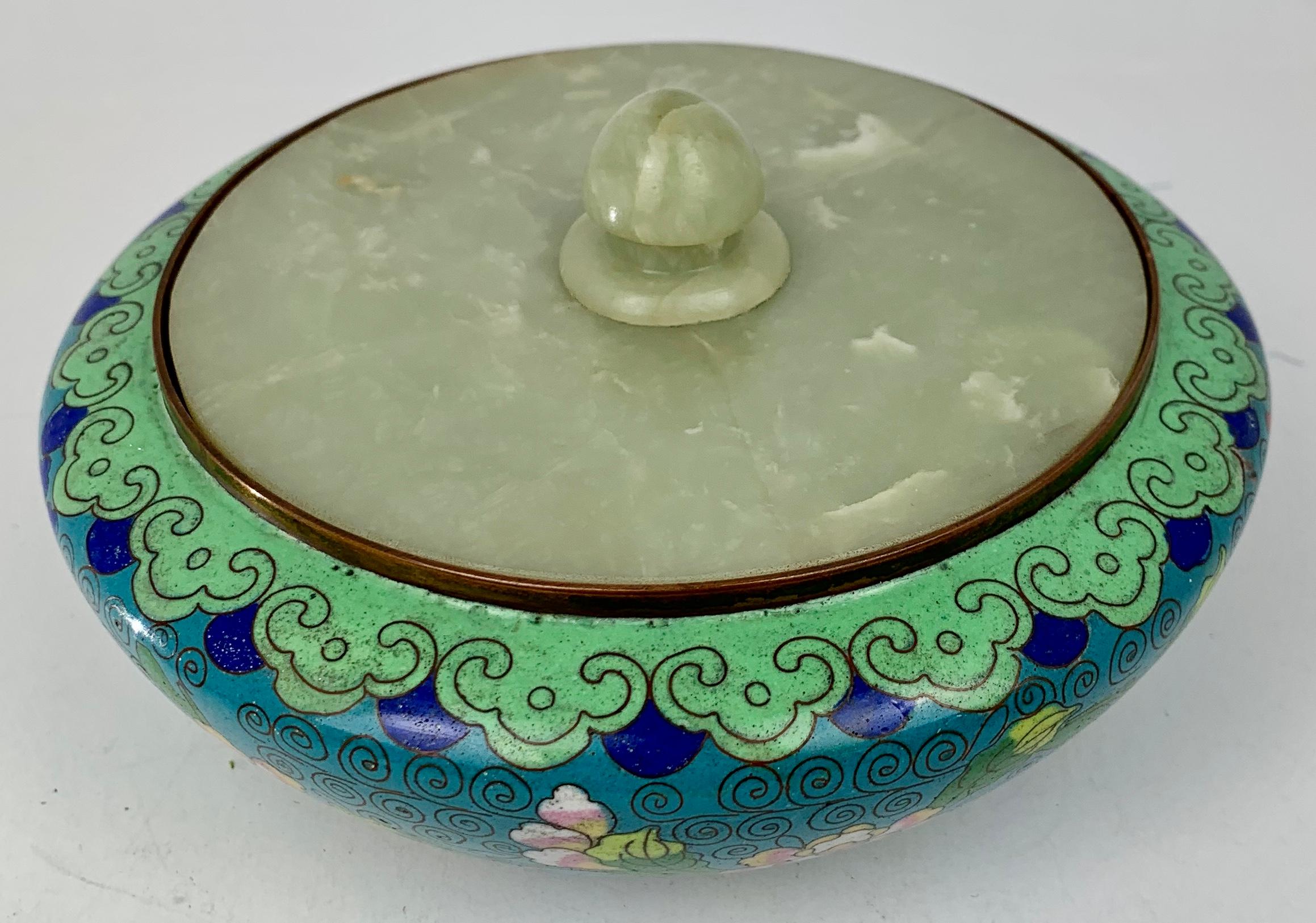 Chinese cloisonné bowl with jade cover. The ground color of the bowl, inside and out, is a deep turquoise. The exterior decoration is of pink, red and blue flowers and their leaves in shaded enamels. The cloisons are in a scroll shape and forming a