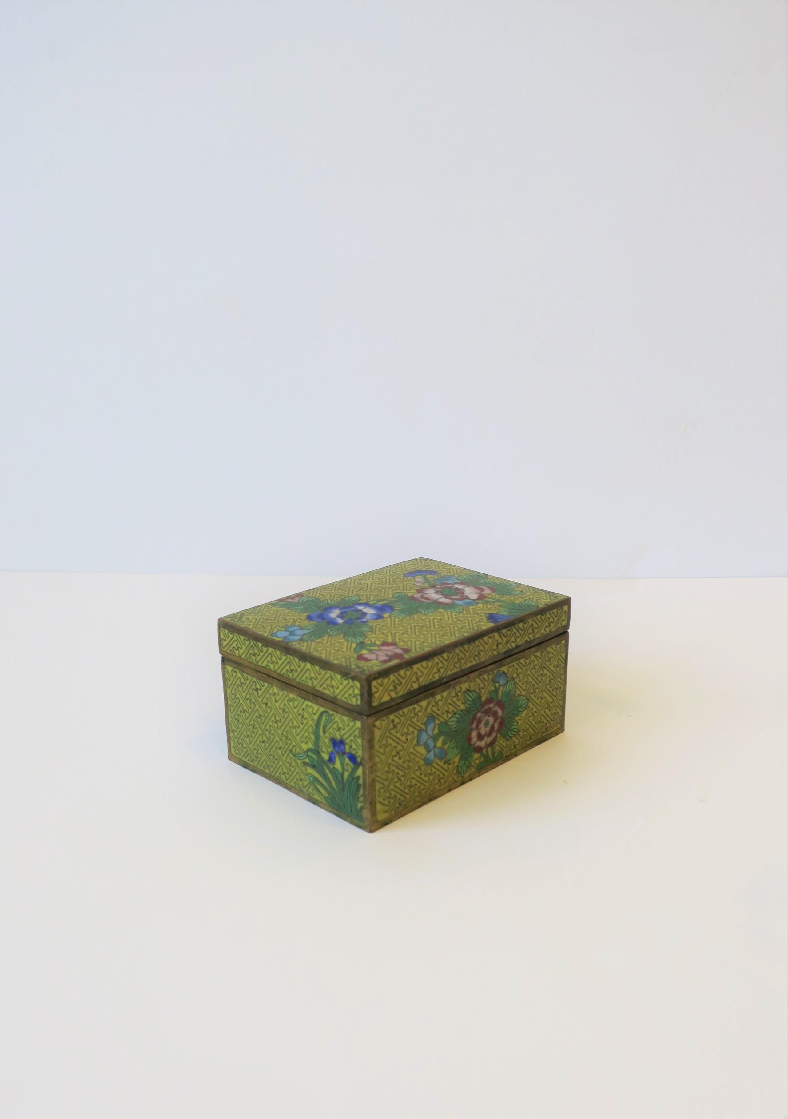 A beautiful Chinese Cloisonné enamel and brass box, circa early 20th century, China. Box is predominantly yellow enamel with detailed blue, white, pink and red flowers, with green leaves and grass. A great box for a vanity or desk area. Box