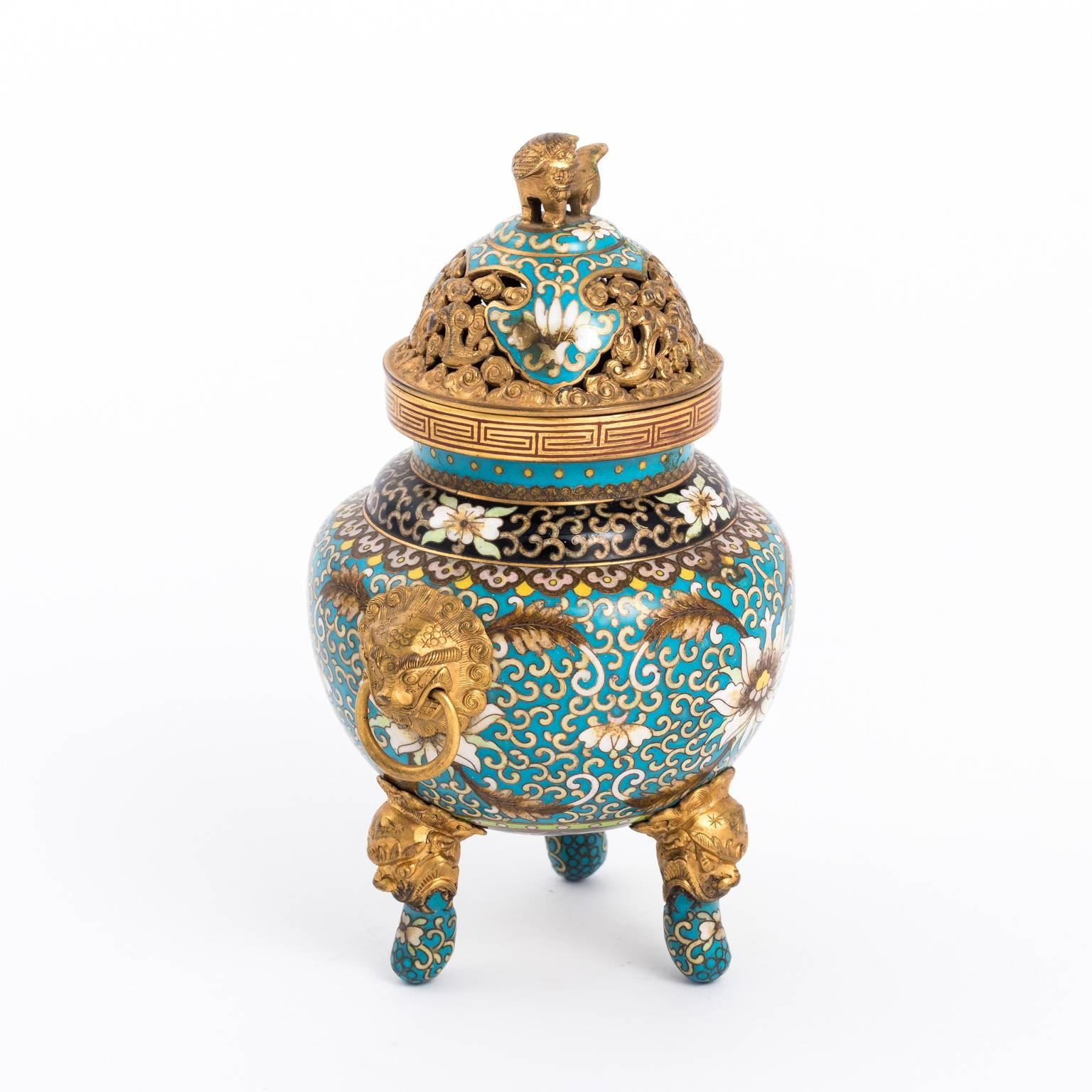 Chinese cloisonné censer for storing incense that is detailed with lotus flowers and brass dogs, circa early 20th century.
