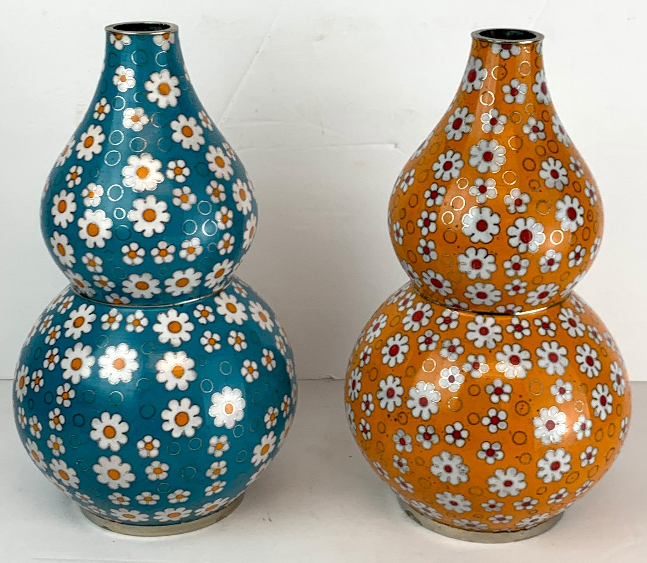 Chinese cloisonné daisy motif double gourd vases attributed, Fabienne Jouvine, sold individually.
Each one profusely decorated with daisy's and rings. One vase with blue background, one with orange background. Please specify by color (Blue or