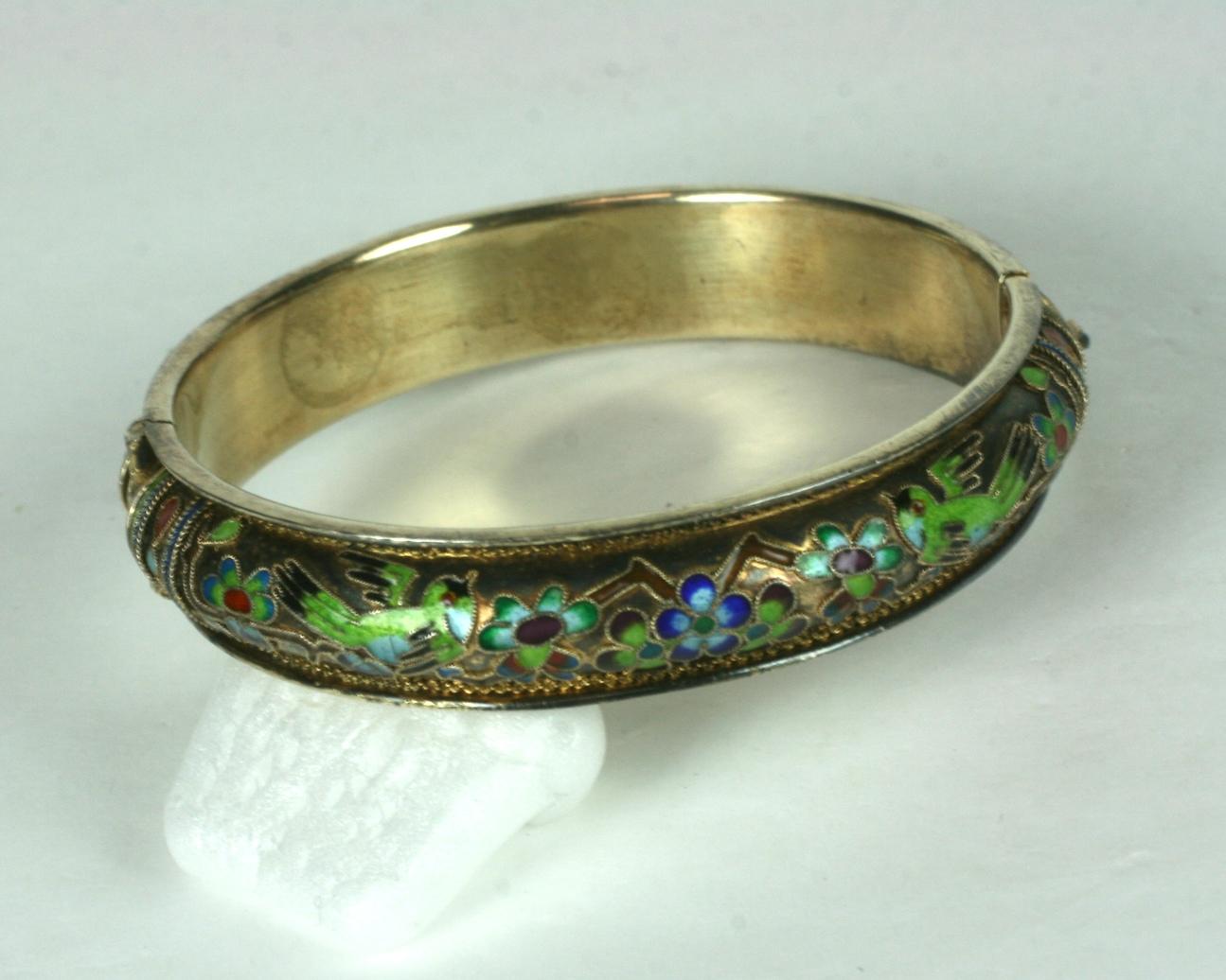 Chinese Cloisonne Enamel Bangle on silver vermeil base. Elaborate enameled designs with birds in flight within flowers. Side hinge opening. 
2.25 interior diameter opening. .5