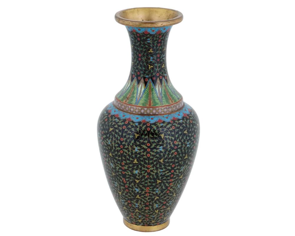 Vase chinois en émail sur laiton. Il possède un corps classique et arrondi qui se rétrécit jusqu'à un manche étroit. Orné d'émaux polychromes aux motifs de feuillages et de fleurs réalisés selon la technique du cloisonné. La base est ronde et dorée.