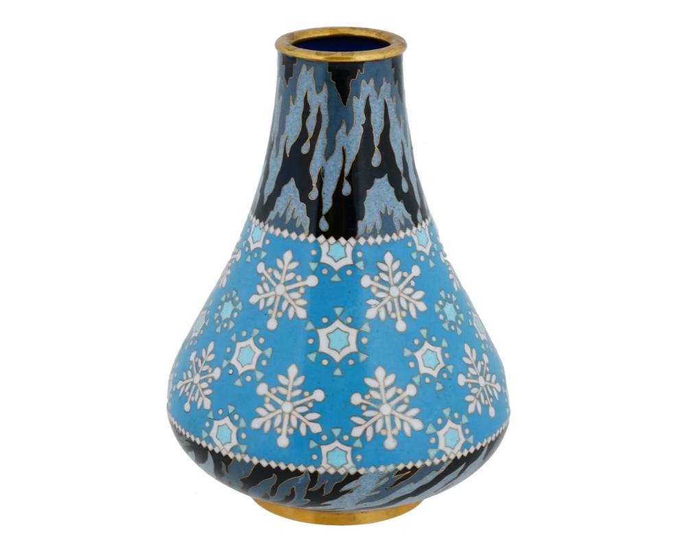 A Chinese brass vase, decorated with an enamel snowflake pattern in cloisonne technique. The vase has a classic, round body, widening towards the bottom, and tapers to a narrow neck. The body of the vase is divided into three distinct sections. The