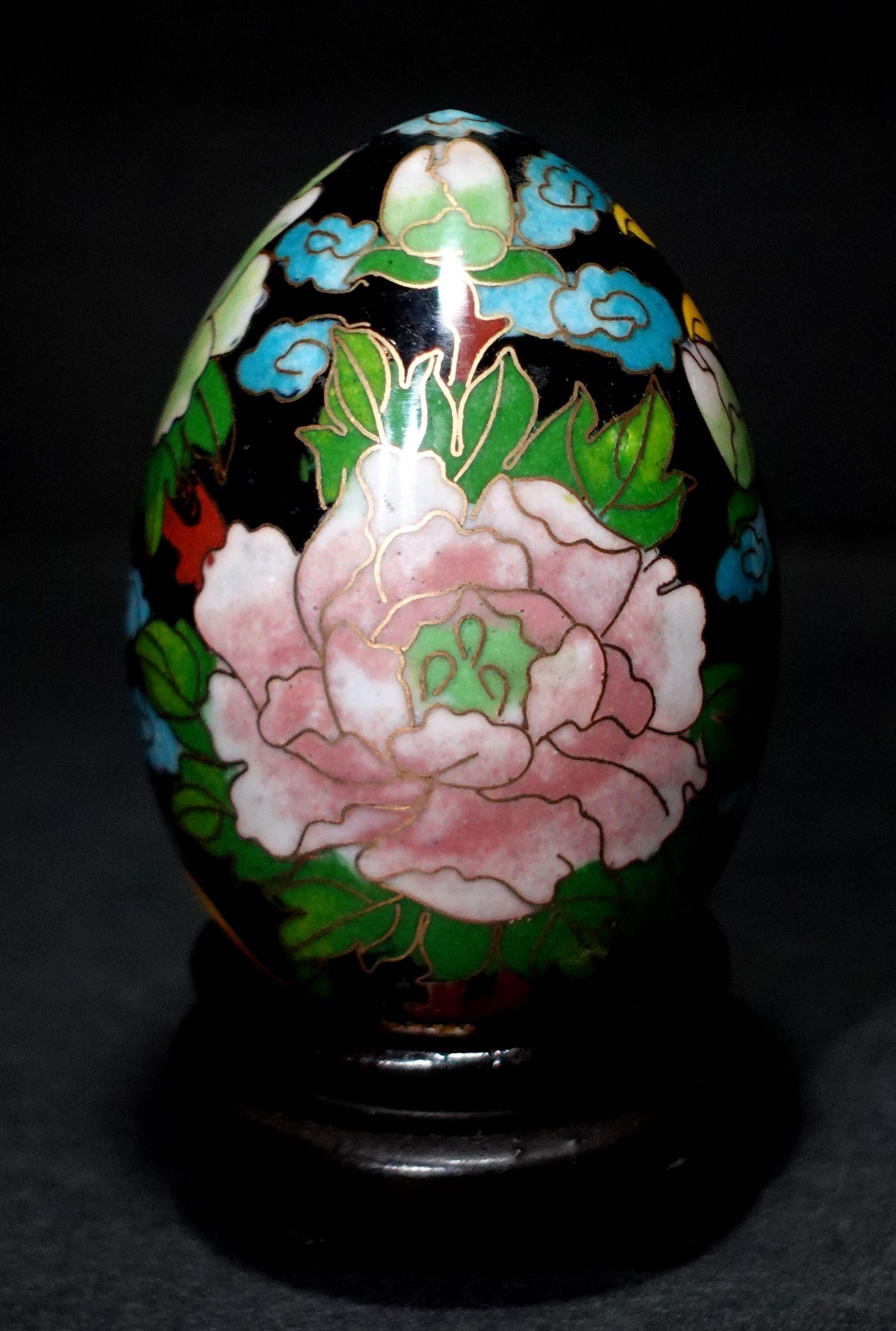 Presenting a beautiful Chinese cloisonné enamel egg depicting flowers and bird with a wood stand, early 20 century.