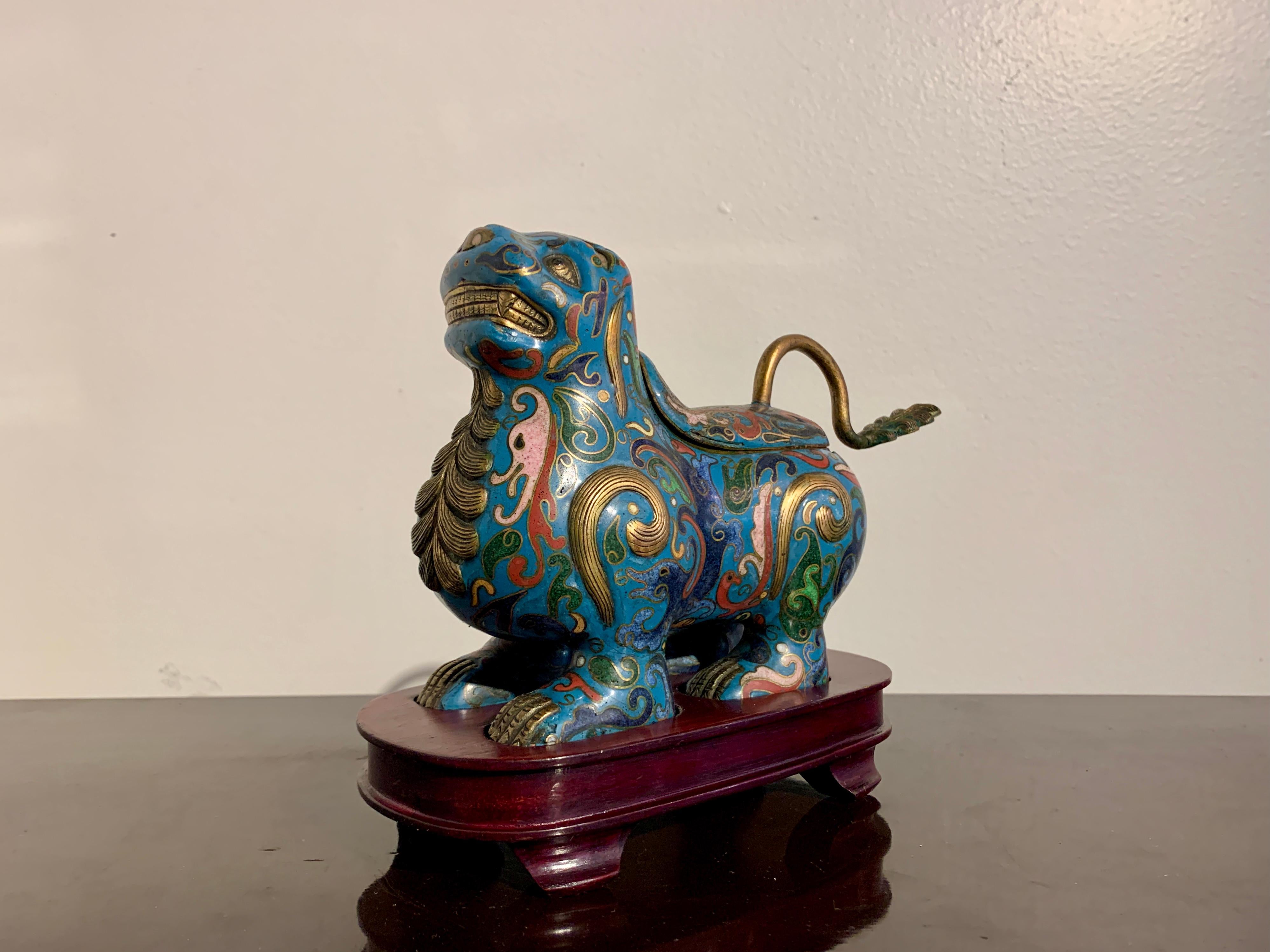 A charming and quirky Chinese cloisonné censer in the form of a lion, Republic Period, early 20th century, circa 1920s or 1930's, China. 

The cloisonné lion with a goofy expression on its face, its lips pulled back in an awkward smile, teeth and