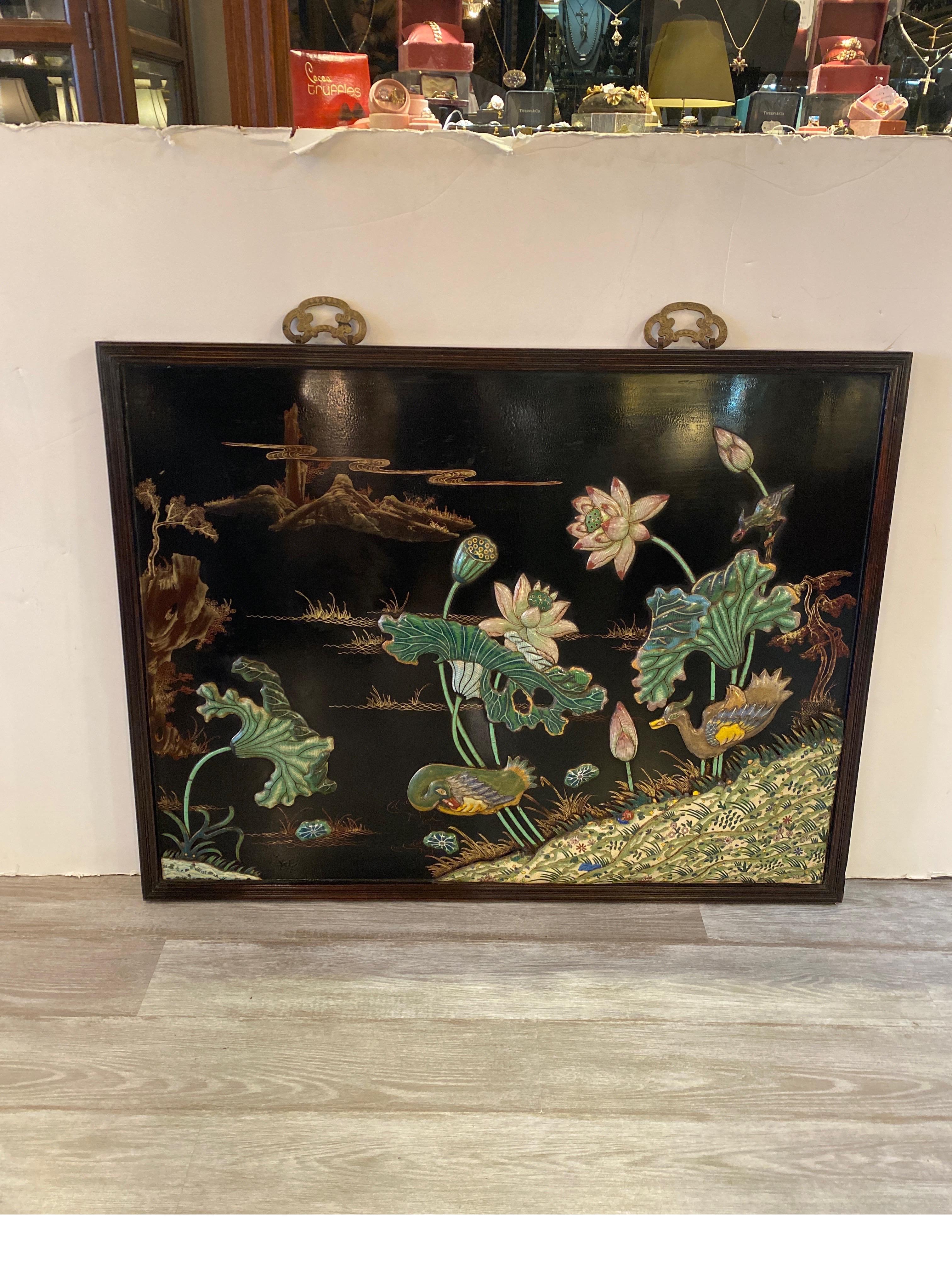 Exceptional chines lacquered panel with enameled chinoiserie mounts depicting stylized ducks with water lilies almost three dimensional. The black background with a walnut color frame.