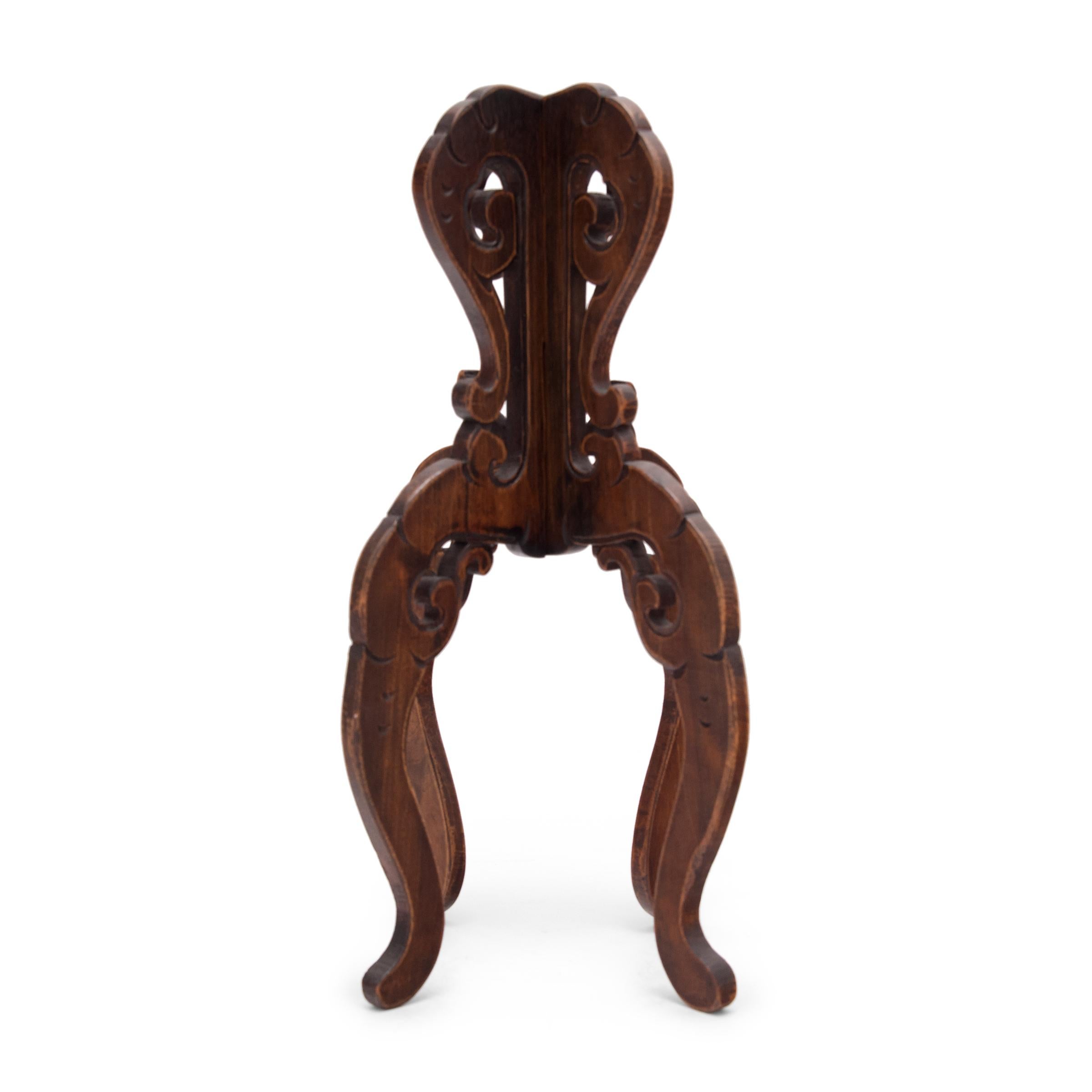 Out of context, this carved wood hat stand has a curious, octopus-like appearance. Carved with cloud-form flourishes, the folding hat stand displays the opulence of court fashion, where rank and status was expressed through fashion and its