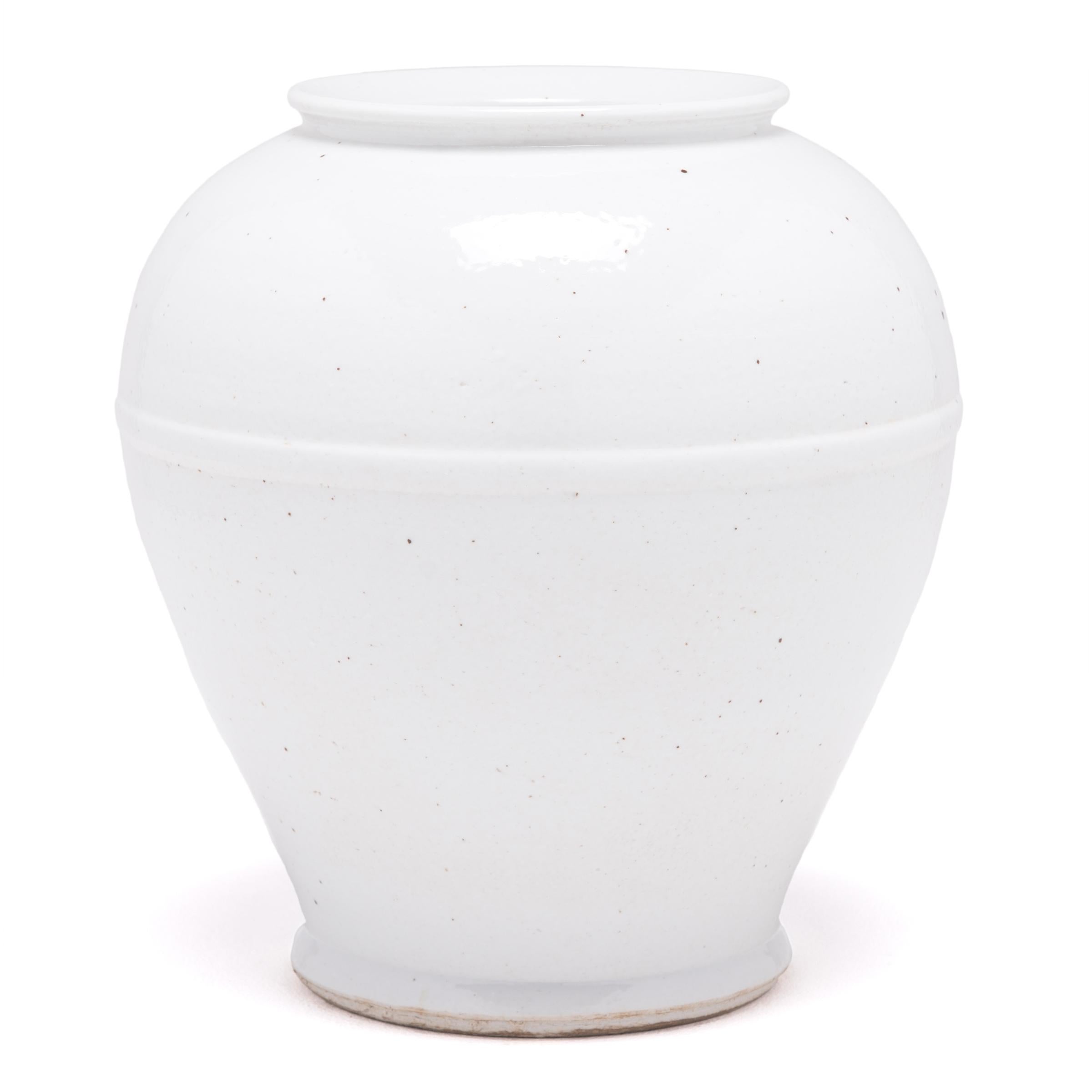 This contemporary tapered stoneware vase reinterprets the classic curves of traditional Chinese ceramics with simplified lines and a rich, white glaze. A subtle raised band encircles the vase where its two separate parts were conjoined.
 