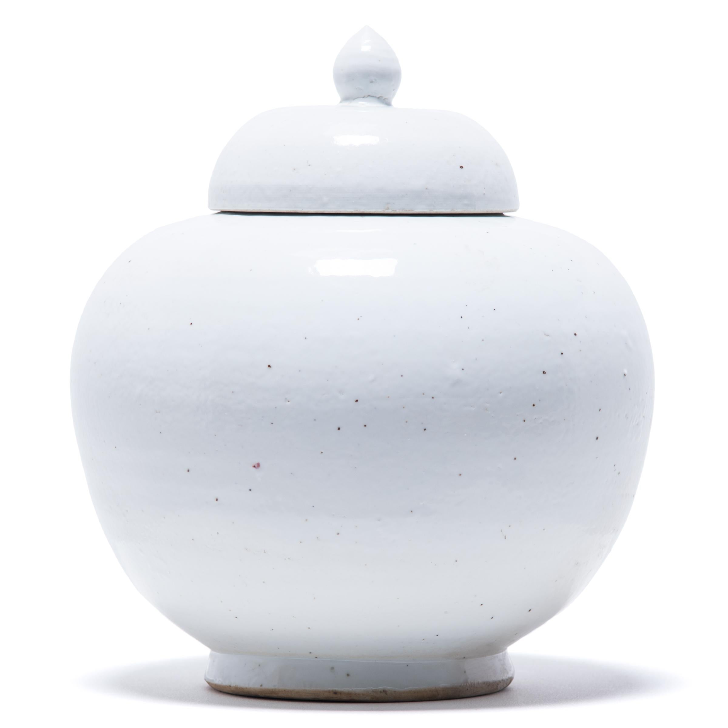 A milky white glaze emphasizes the sculptural form of this contemporary update on a Chinese classic. Refining the traditional onion shape, the lidded jar’s monochromatic look draws attention to its clean lines and subtle graduated curves.