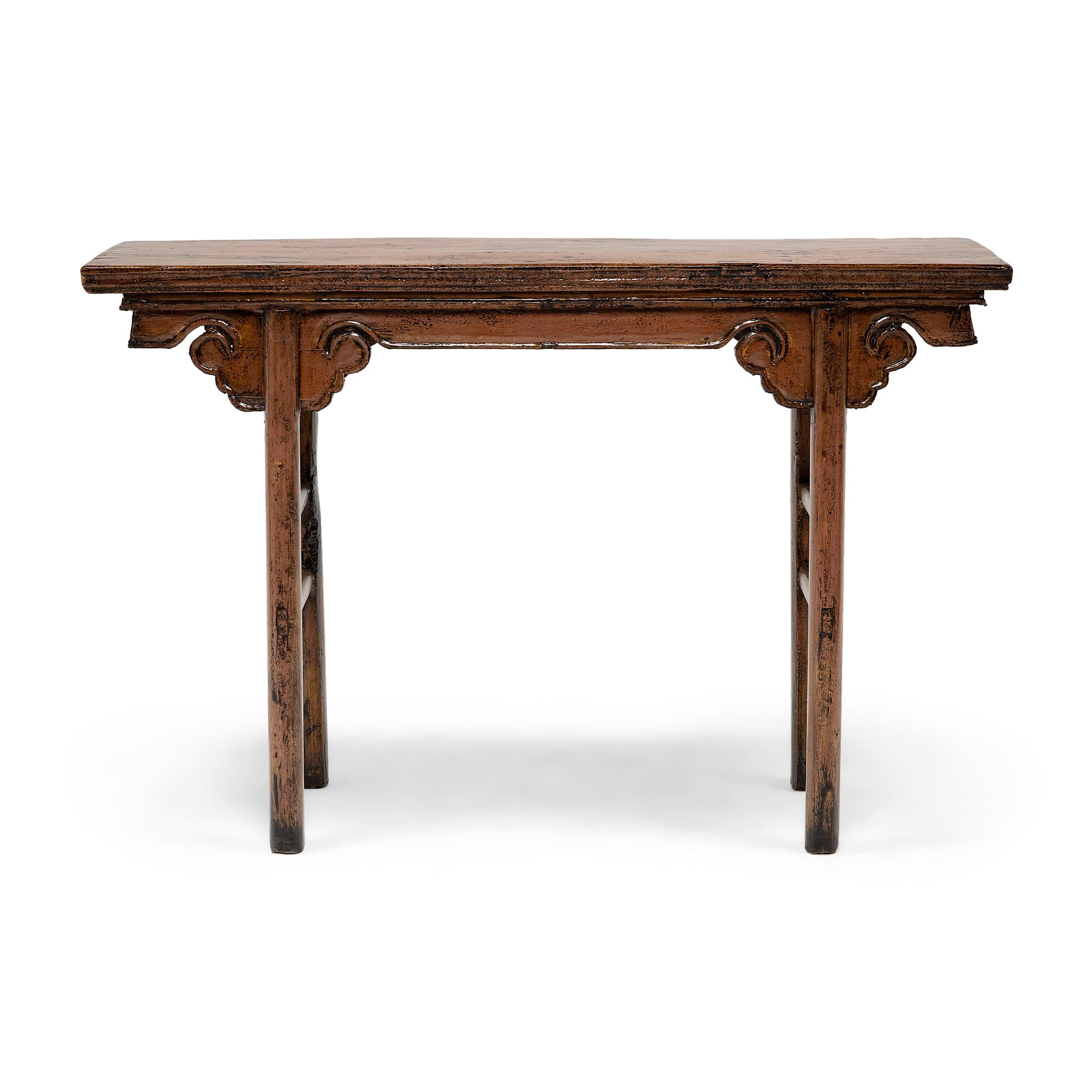 This late 19th-century Chinese altar table expresses Ming-dynasty tastes with clean lines and a simple silhouette. Minimally decorated, the table is constructed with straight legs and double stretchers. The legs meet at beautifully stylized