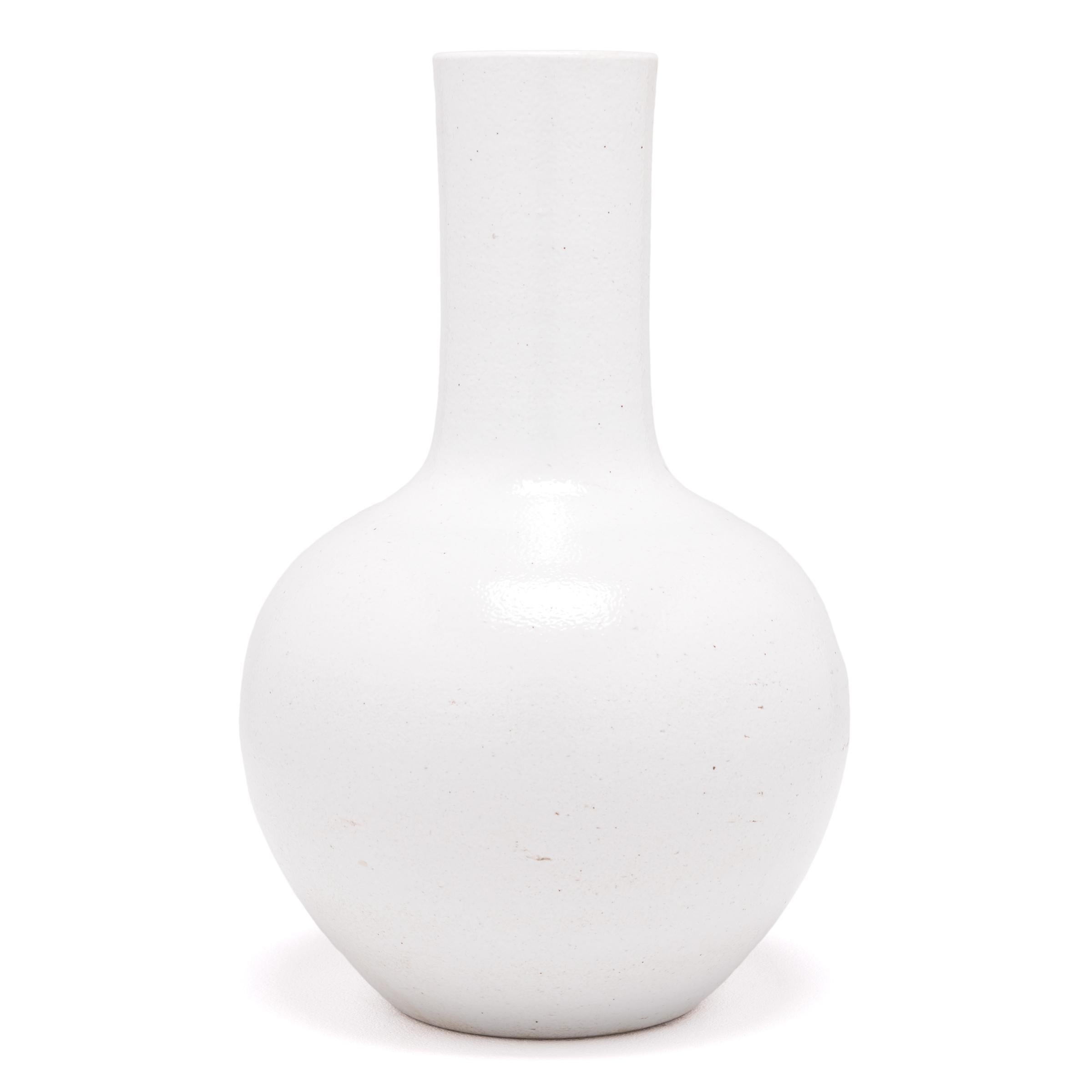 S'inspirant d'une longue tradition chinoise de la céramique, ce vase à long col est recouvert d'une glaçure blanche laiteuse. Sculpté par des artisans de la province chinoise de Jiangxi, ce vase réinterprète la forme traditionnelle du col de cygne,