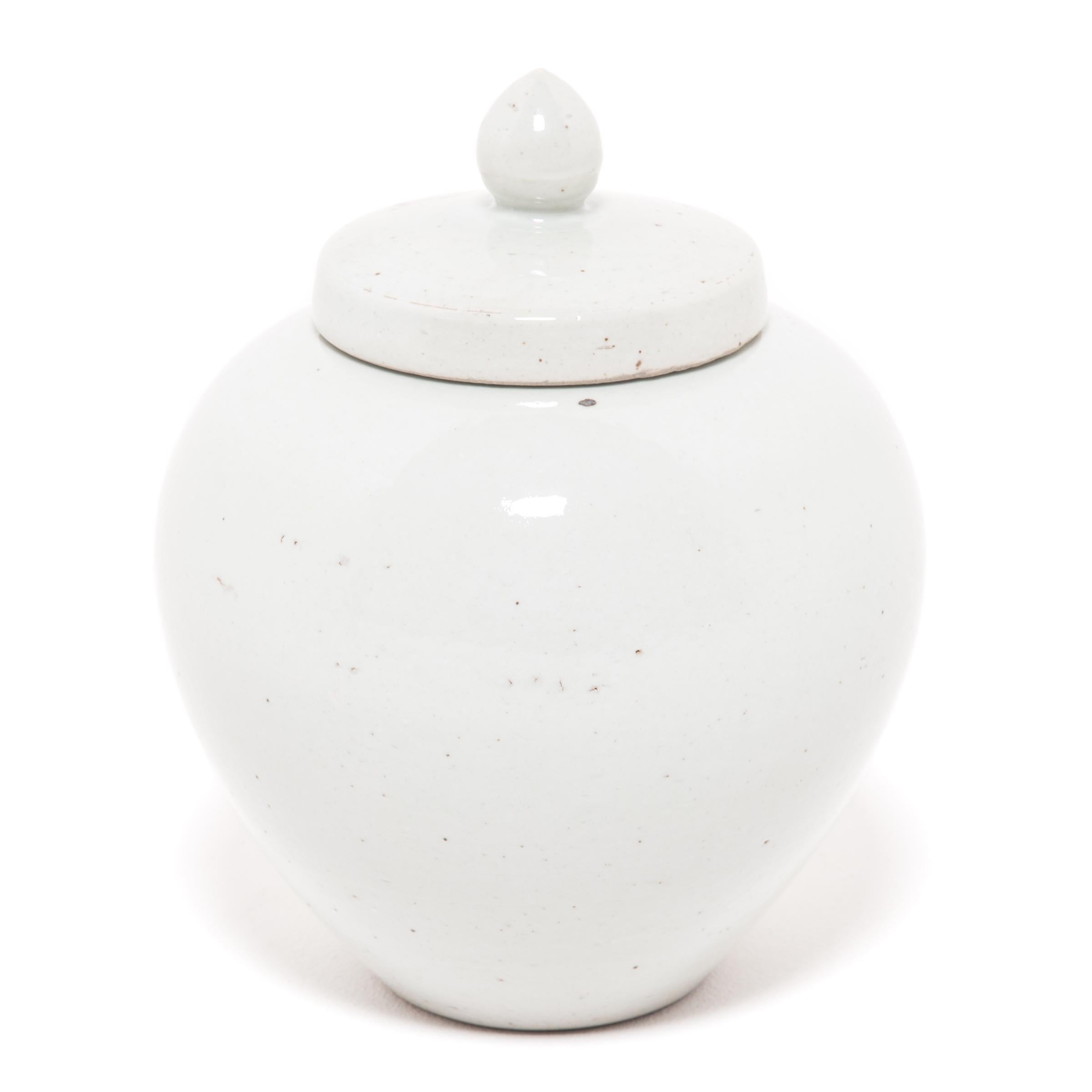 Drawing on a long Chinese tradition of monochrome ceramics, this round porcelain jar is glazed in serene, cloud-inspired white with celadon undertones. Sculpted by artisans in China's Zhejiang province, the jar has an impressive sculptural form with