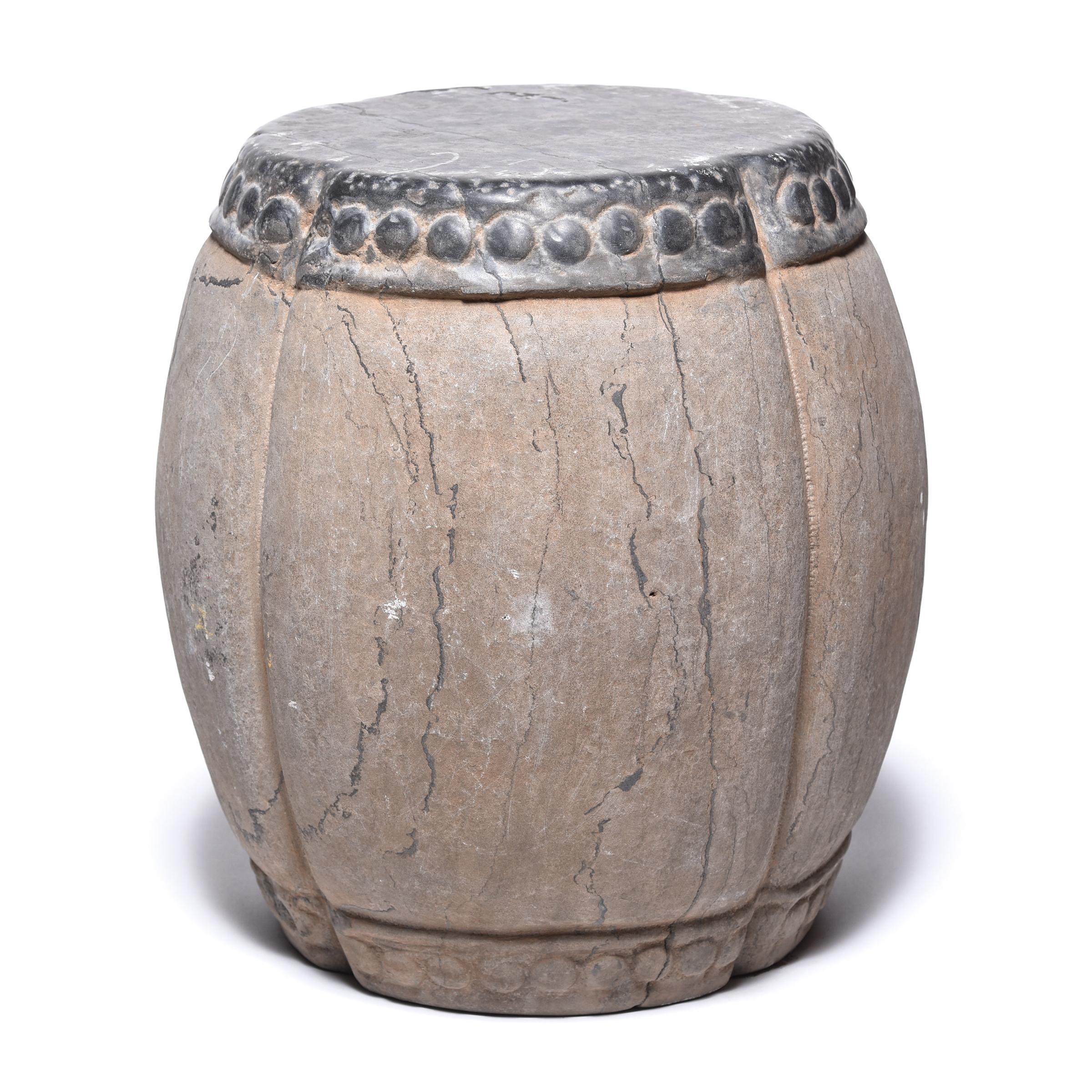 Marked by expressive veining, this handsome stool was carved in China’s Shanxi province out of a piece of solid limestone. Ribbed and rounded, the stool suggests a melon, an ancient Chinese symbol of perpetuity. A pattern of boss-head nails ringing