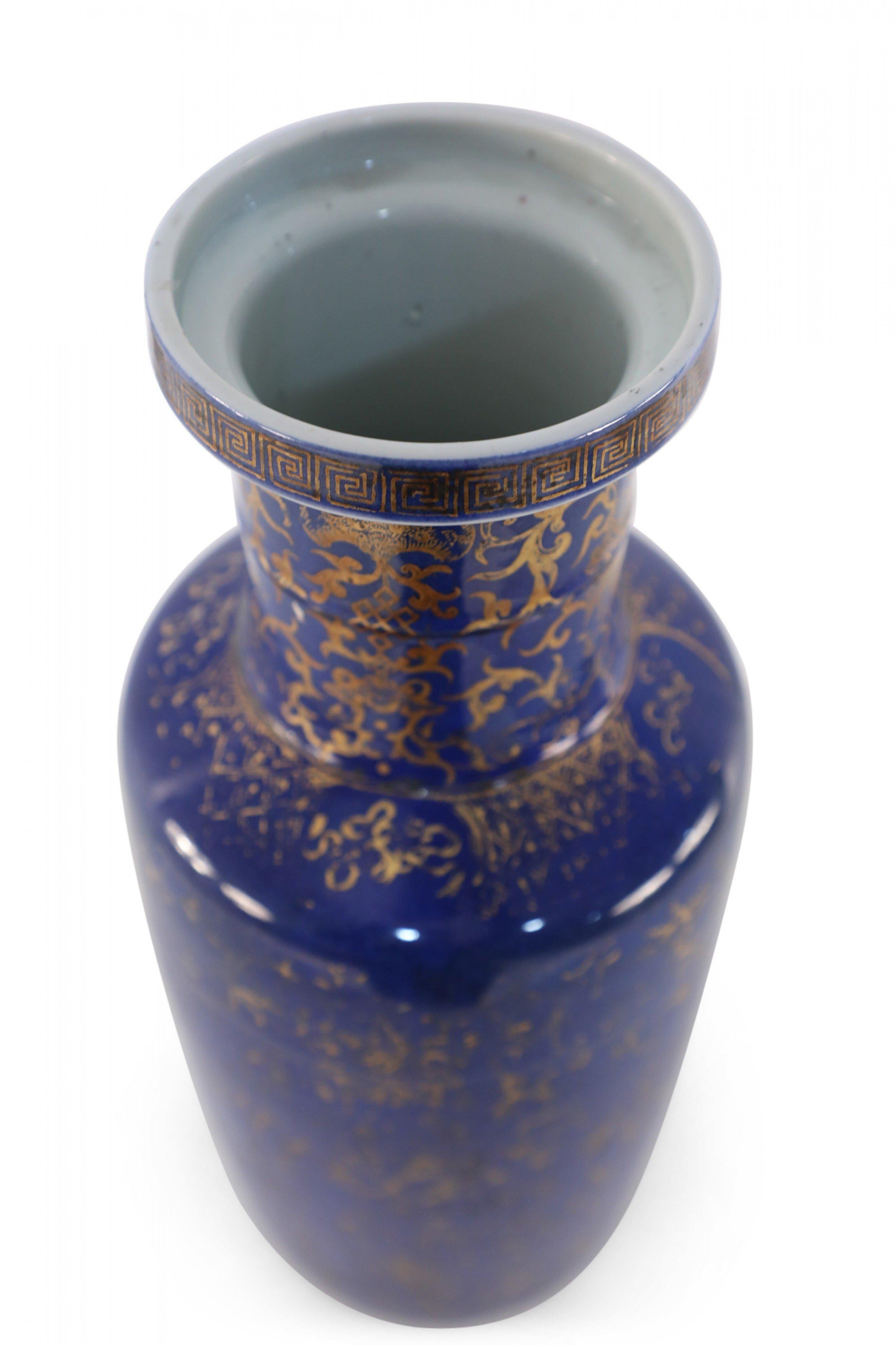 Ancien vase chinois (début du 20e siècle) en porcelaine bleu cobalt décoré d'une variété de motifs dorés comprenant des koï, des vignes, des plantes, et un bandeau en forme de clé grecque autour du col.
 