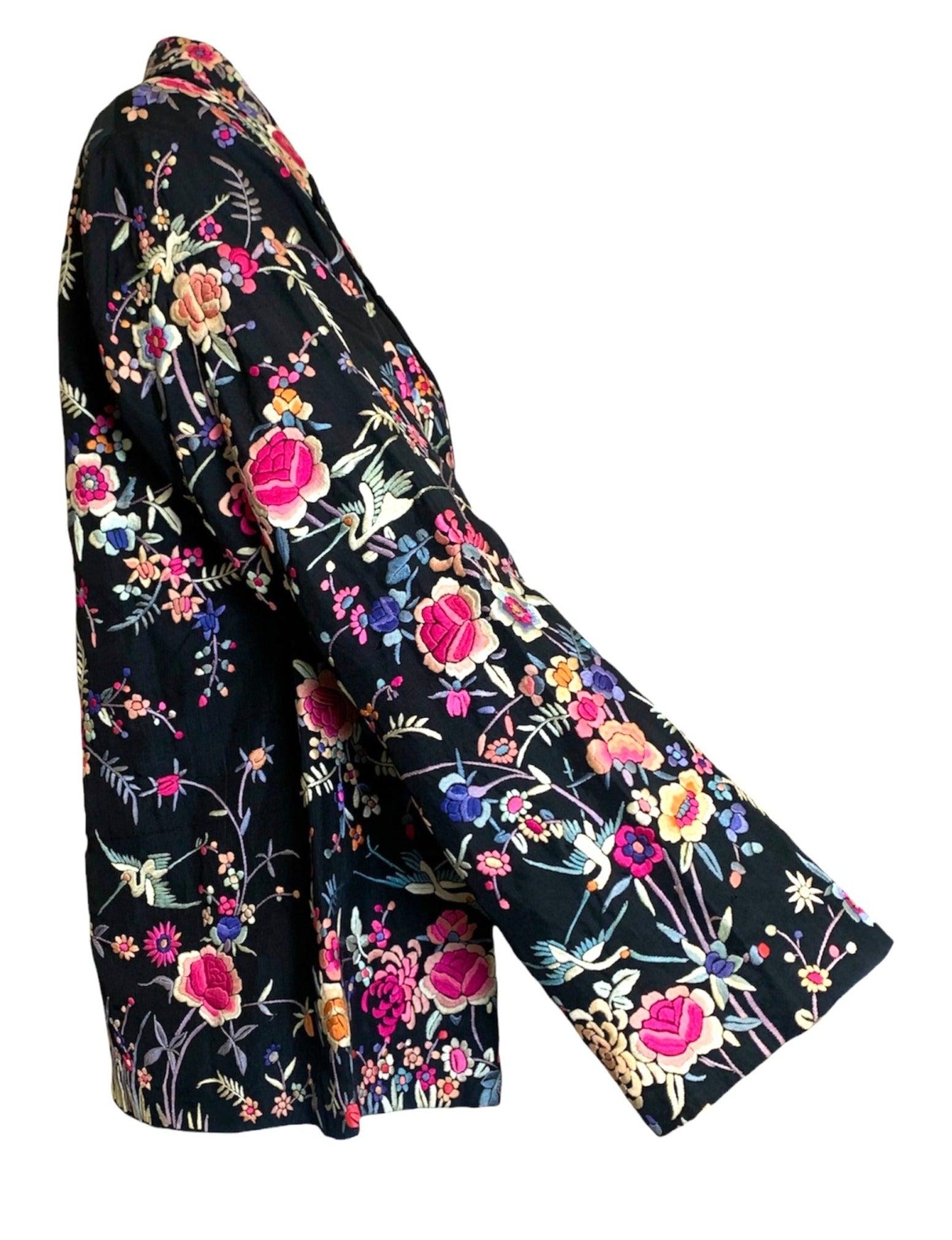Schöne chinesische 1920er Jahre schwarze Seidenjacke.  Starke Stickerei  Das helle und farbenfrohe Blumenmuster wird von Hand gefertigt. Ganz aus Seide, vollständig gefüttert und mit verdecktem Knopfverschluss auf der Vorderseite. Breiter, spitzer