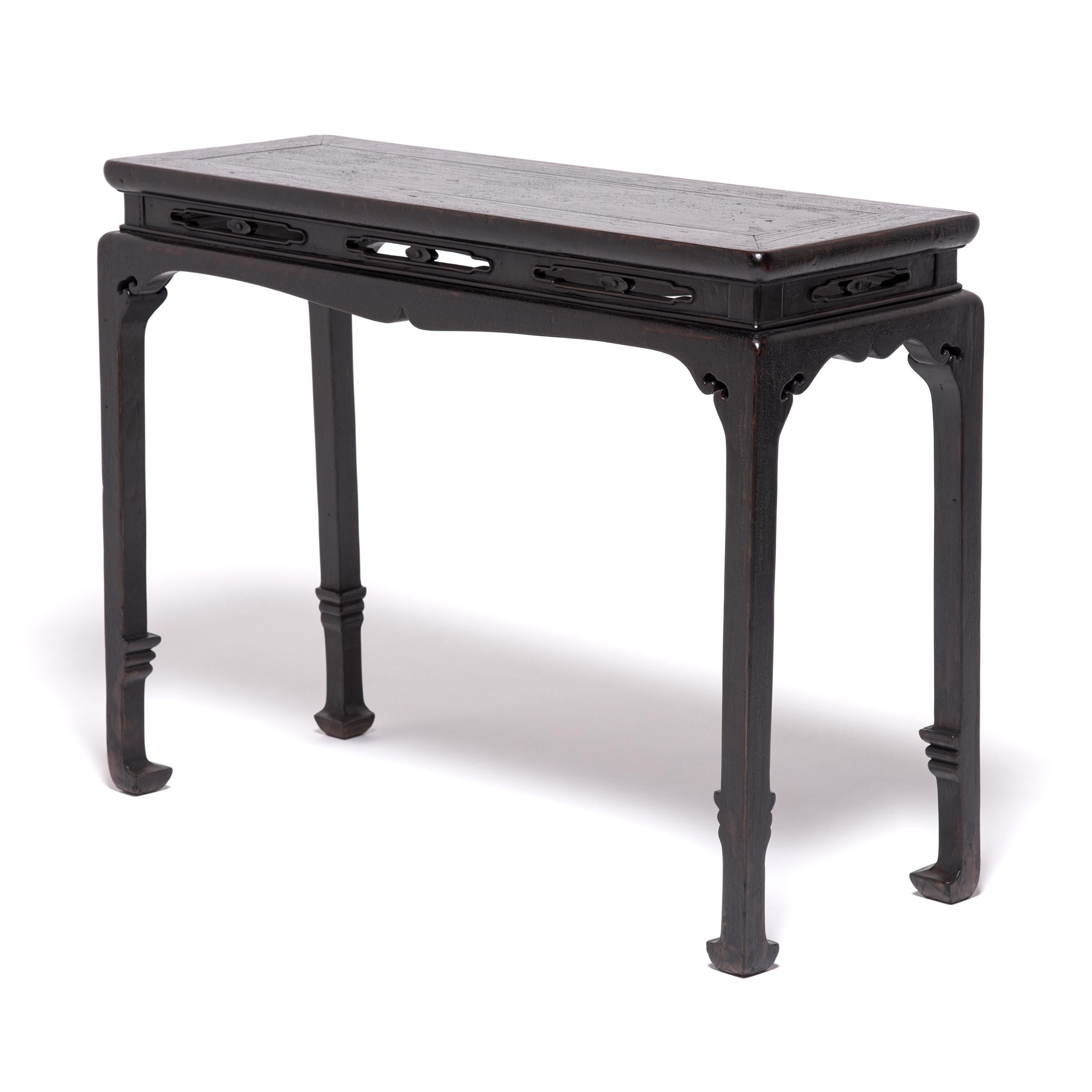 Handcrafted of northern elmwood over a century ago, this simple console table expresses the clean lines and elegant restraint that make Qing-dynasty carpentry so sought after. Emphasizing the table's refined form, a simple cusped apron flows into