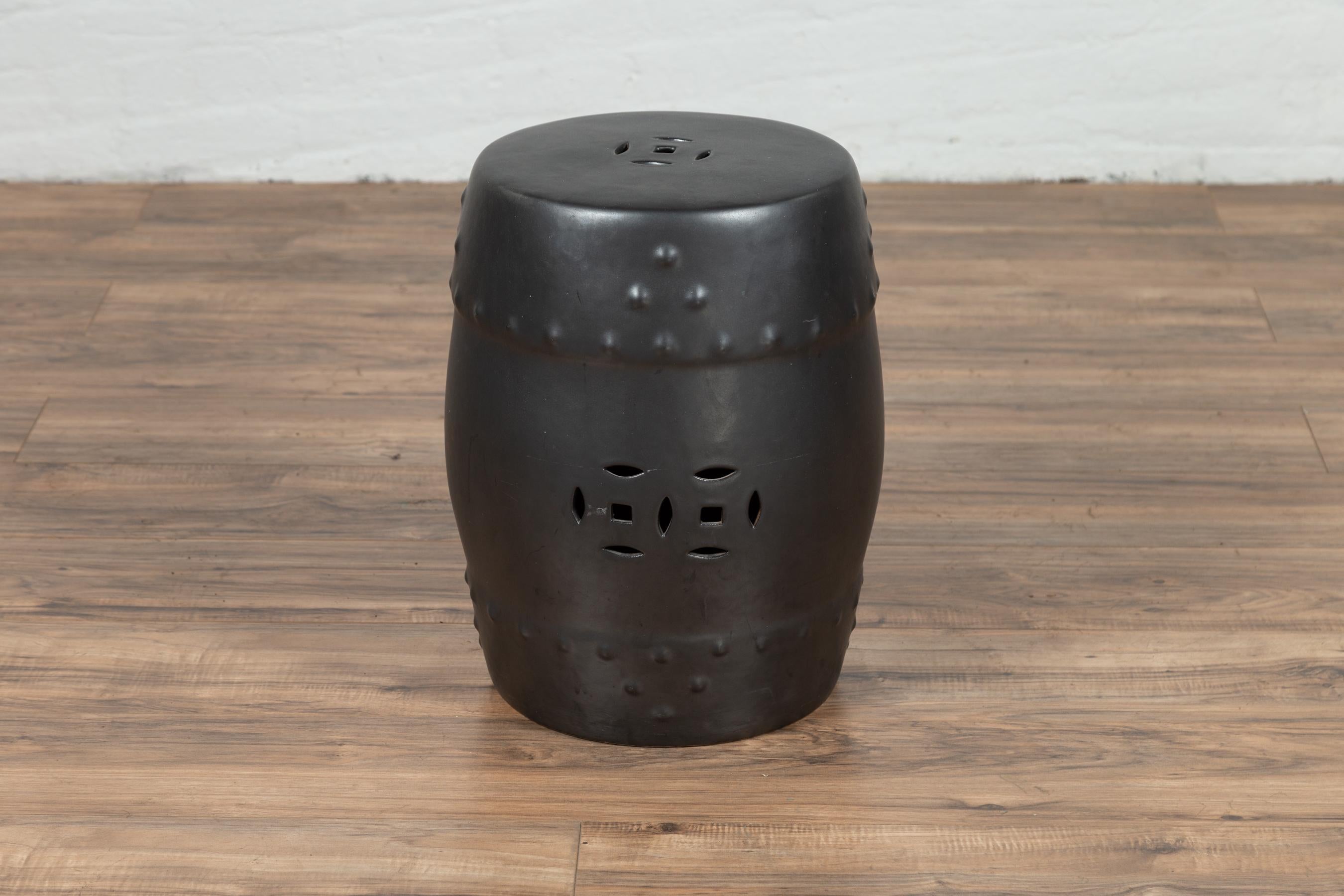 A Chinese contemporary cobalt grey ceramic garden stool with pierced and raised motifs. This stylish garden stool charms us with its cobalt grey finish and delicate décor. Its raised stud-style motifs, added to the geometric pierced patterns that