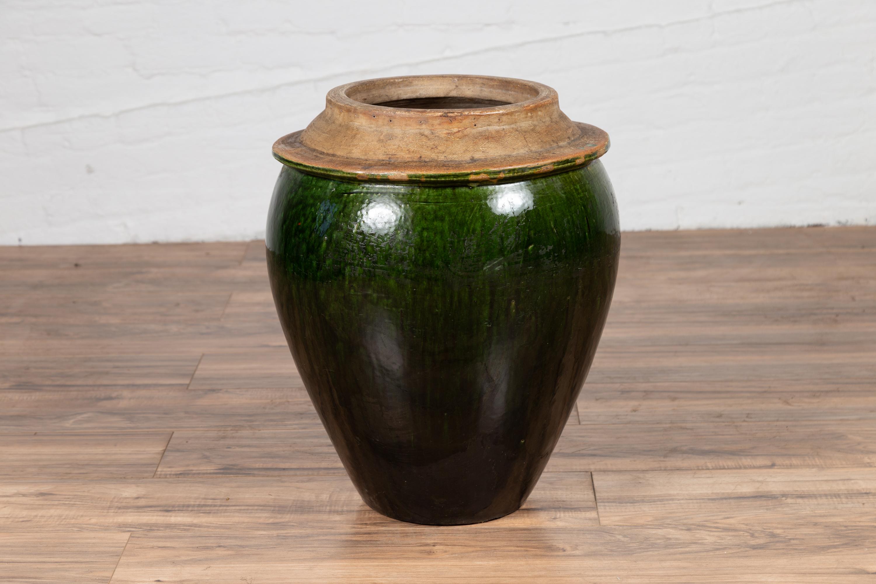 A Chinese contemporary green glazed water jug with unusual design and calligraphy. Born in China, this handsome pottery features a green glazed body, topped by a flaring neck. The belly is adorned with lovely Chinese calligraphy in the front, that