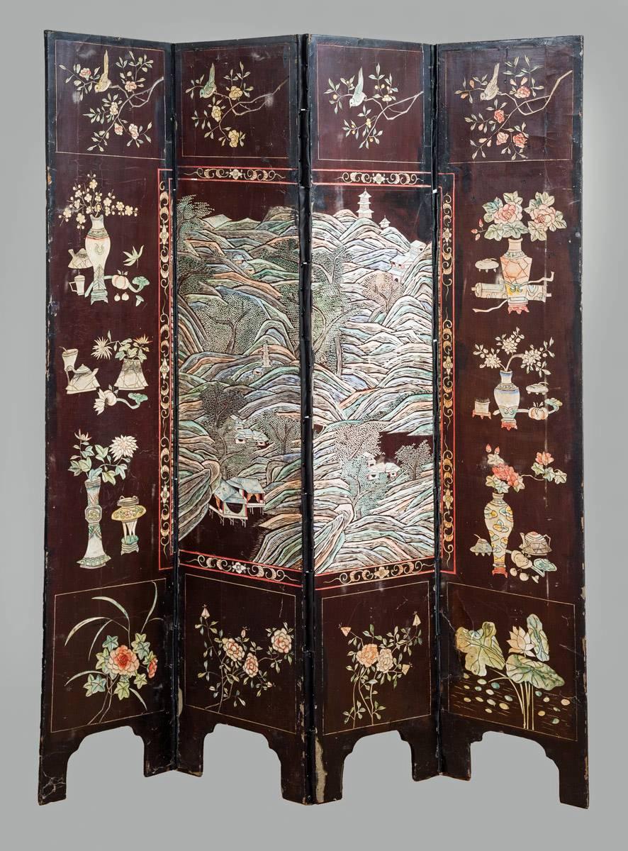 Antique Chinese four-panel Coromandel lacquered screen decorated with carved, incised and painted scenes of palace life in muted tones of blue, green and rose. The back of the screen is decorated with mountain views, trees and flowers. The