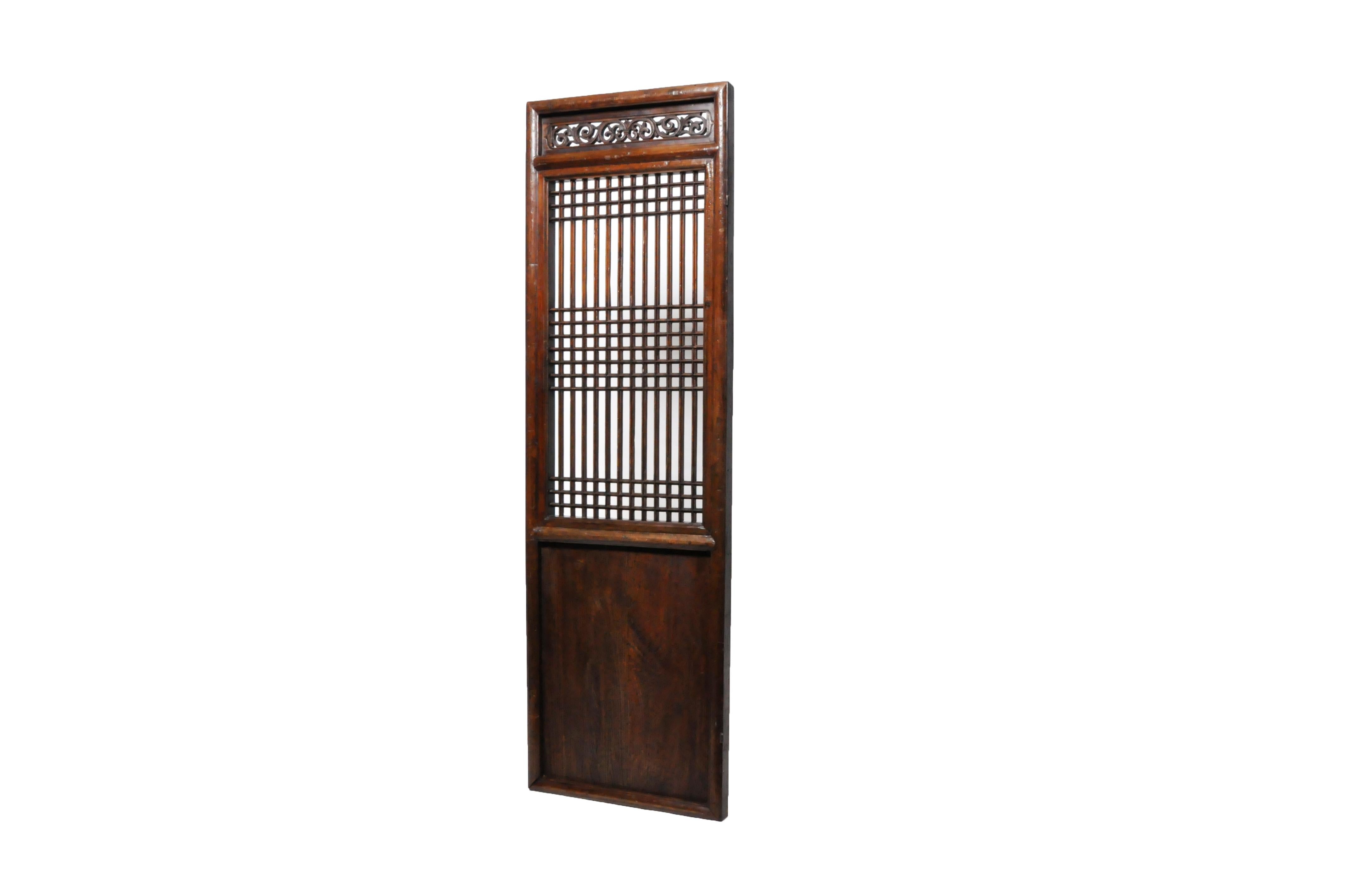 This elm wood door was once part of a large series that surrounded a private courtyard in a Northern Chinese house. It features fine latticework and carved details. The patina is original with the addition of French polish and beeswax. It could be