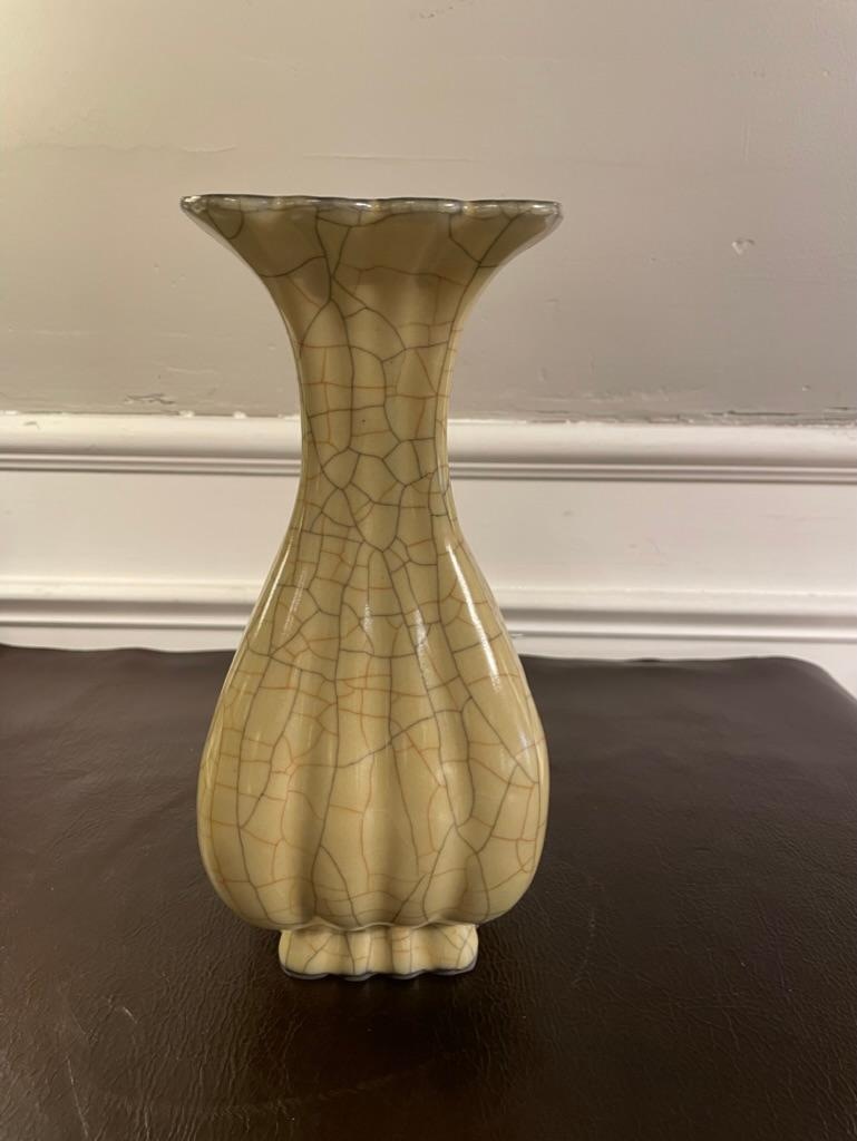 A Chinese crackle glazed ceramic vase of lovely form and proportions. The cream colored glaze crazed with a crackle glaze in cinnamon red and black, the foot and lip rimmed with a silvery gun metal gray. Very elegant form, body of voluptuous melon