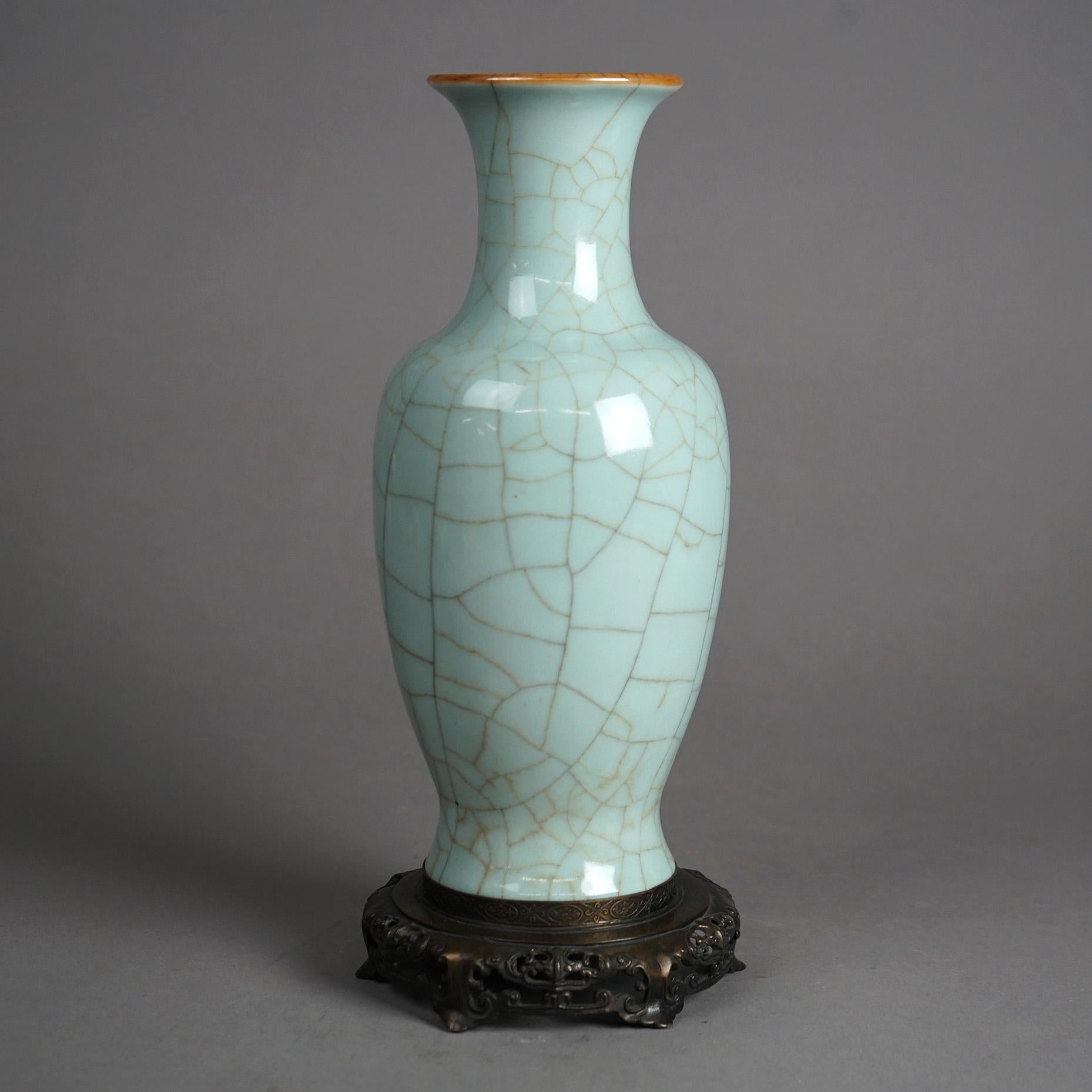A Chinese vase offers pottery construction with crackled celadon glaze, seated on a bronzed cast metal base, 20th century

Measures- 12.75''H x 5.25''W x 5.25''D