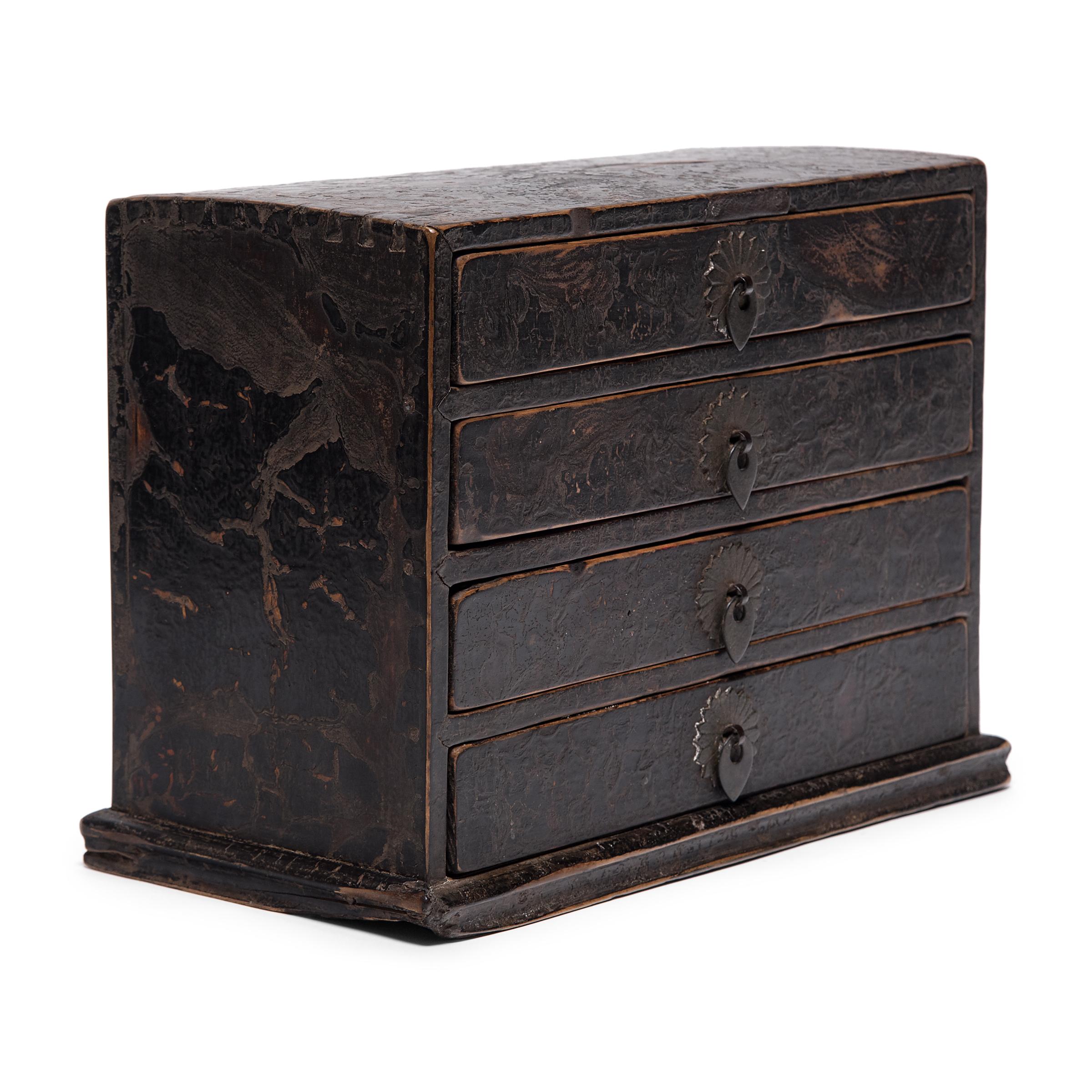 This petite 19th century chest of drawers is a fantastic example of the multifunctional boxes used tabletop in lieu of a larger cabinets. Such boxes were used to store cosmetics, jewelry, documents, and other accessories. This box has four shallow