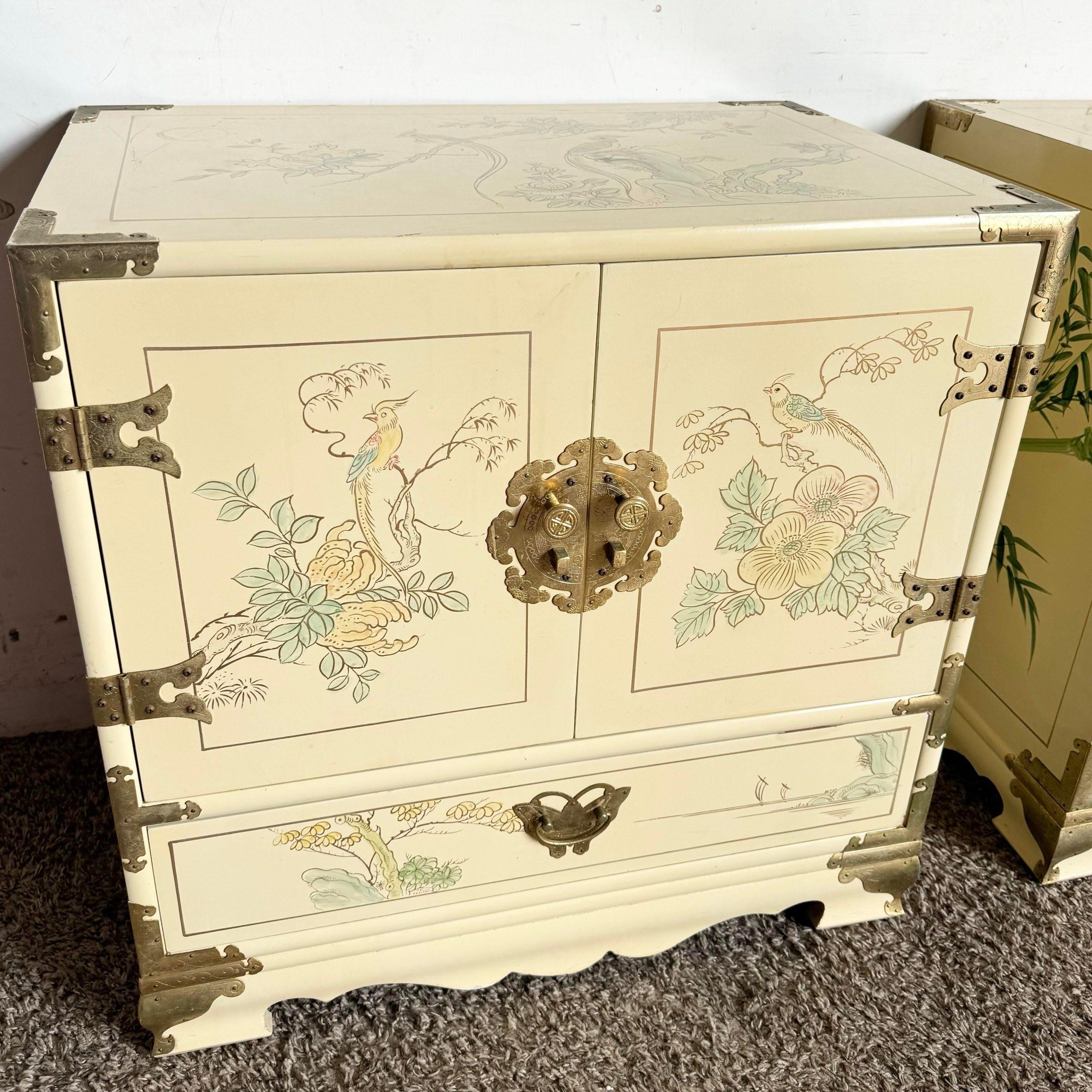 Add a touch of elegance to your bedroom with this pair of Chinese Cream Lacquered and Hand Painted Nightstands. Each features exquisite hand-painted designs and intricate gold accents, showcasing exceptional craftsmanship. The cream lacquer finish