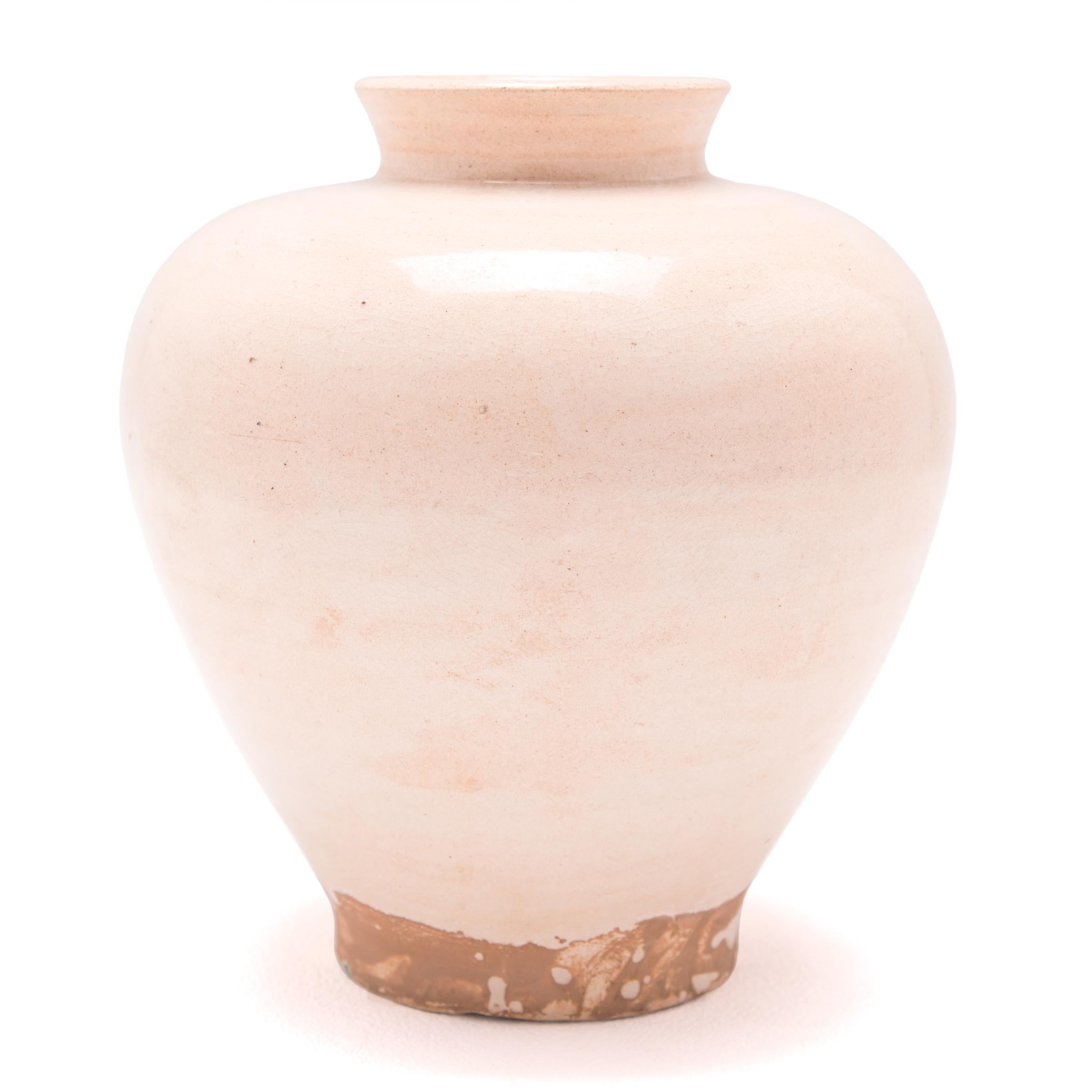 A cream-colored glaze emphasizes the sculptural form of this contemporary version of a traditional Chinese wine vessel. Refining its classic tapered curves, the jar’s monochromatic look draws attention to its elegant silhouette. Featuring an