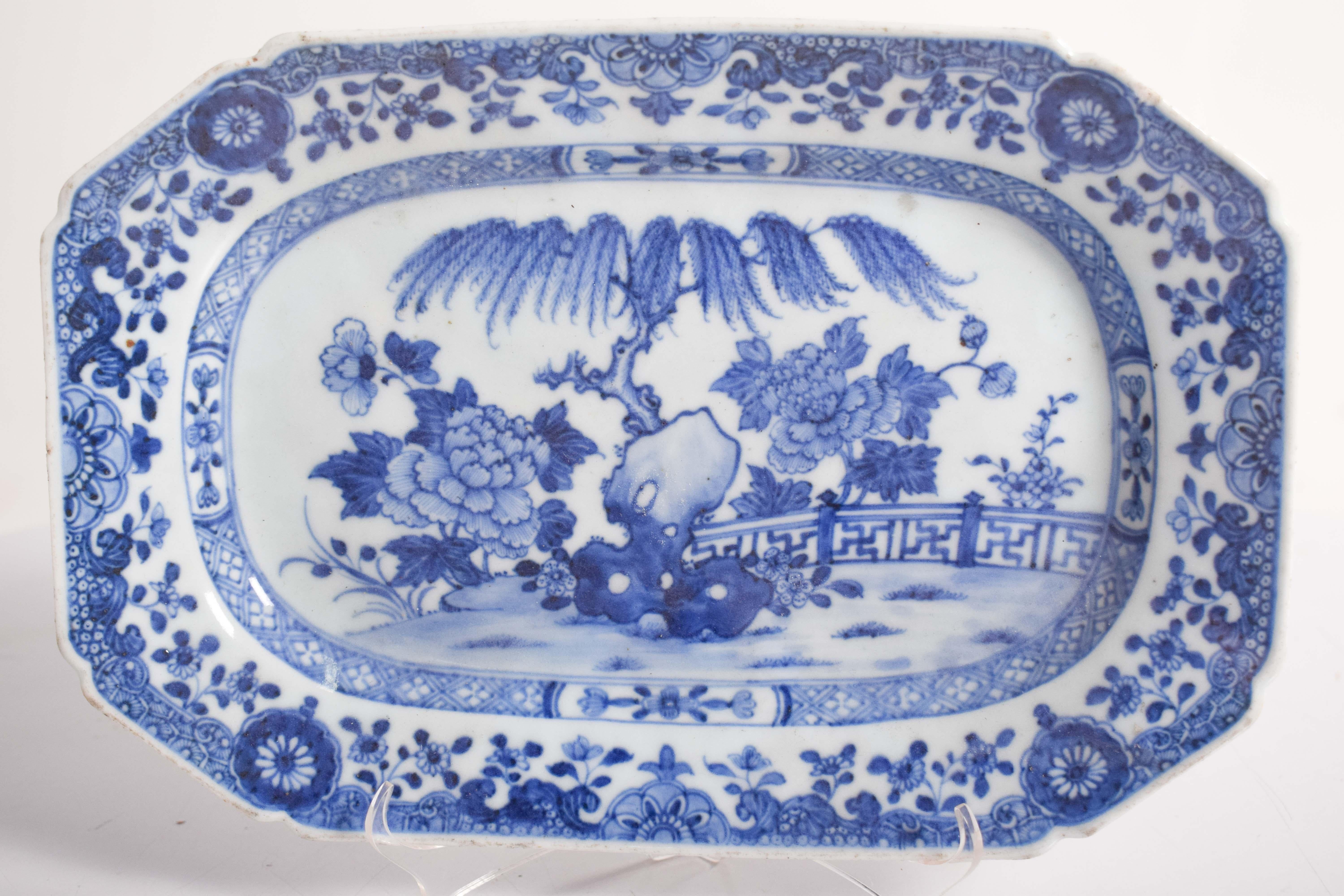 This octagonal serving dish, crafted from fine Chinese porcelain, is a beautiful example of traditional craftsmanship from the East India Company. The dish features a striking blue and white decoration, a hallmark of Chinese porcelain artistry. The
