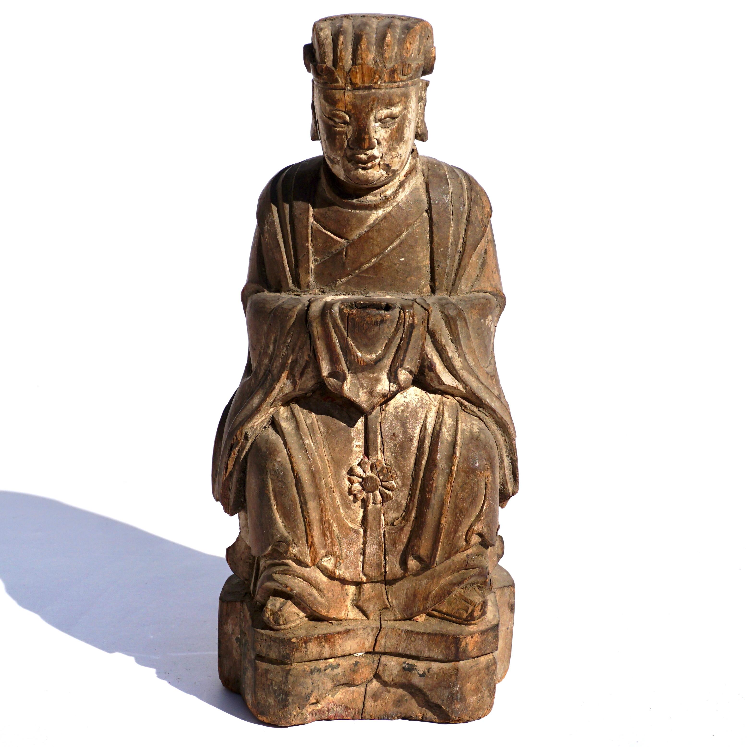 A beautifully wood carved figure of a seated Buddha. Seated with slowing robe with traces of white polychrome mostly on head and neck. Prayer compartment in back. Figures done in this period regularly were modeled into monks and immortals. This