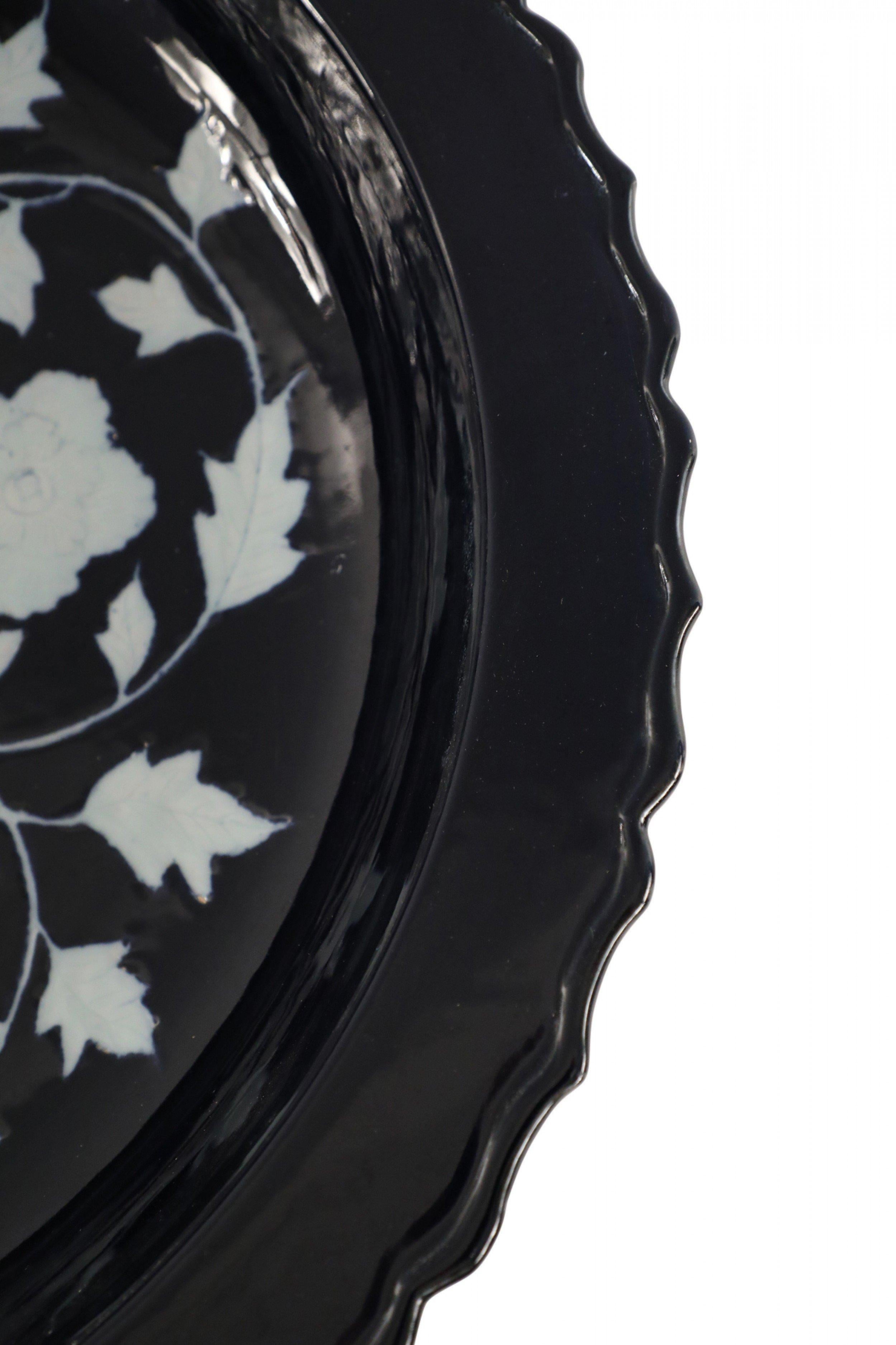 Antique Chinese (13-14th Century) dark blue shallow porcelain centerpiece bowl with scalloped edges and a white floral peony motif in the center.
 