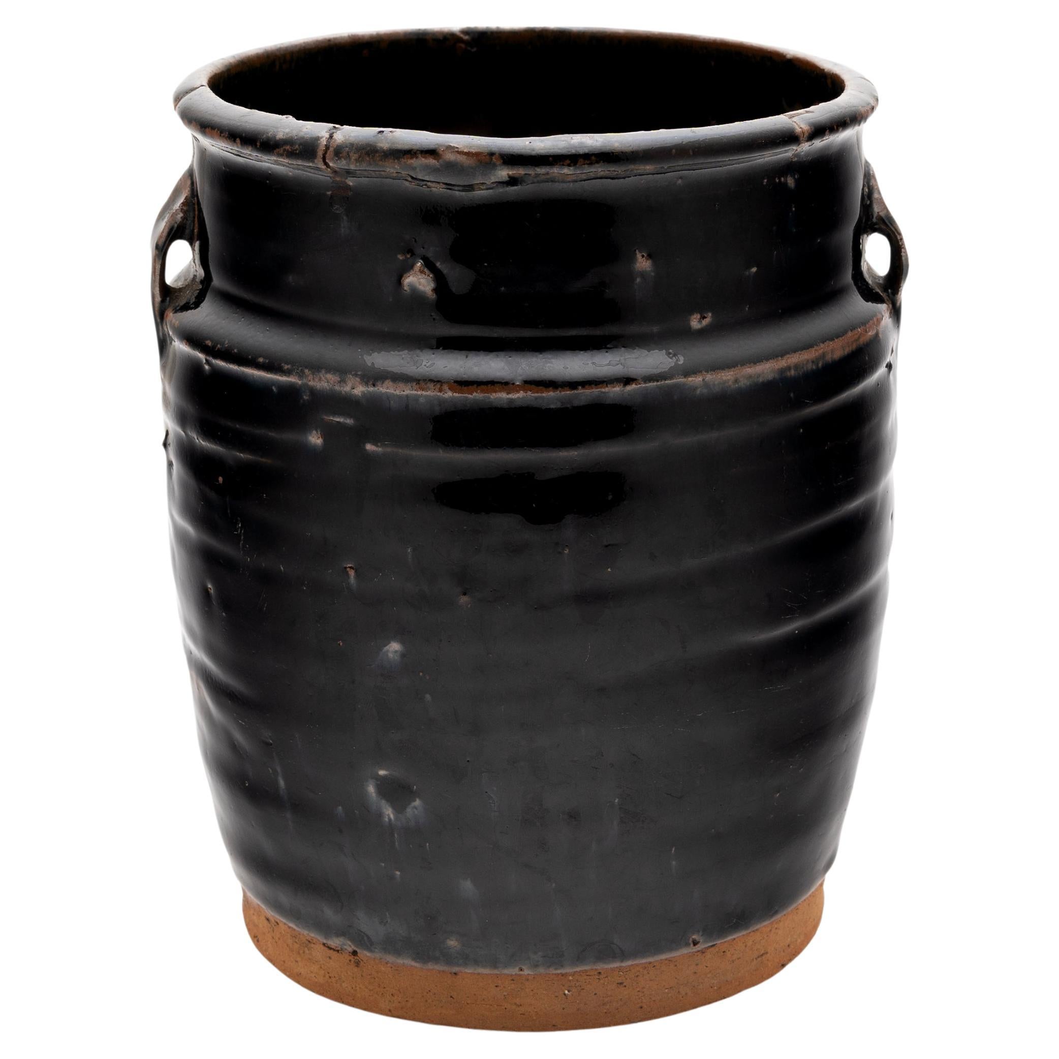 A cool, blue-black glaze coats the stout body of this early 20th-century terra cotta kitchen jar. As evidenced by the glazed interior, the wide-mouth jar was once used daily in a provincial Chinese kitchen for fermenting foods and condiments. The
