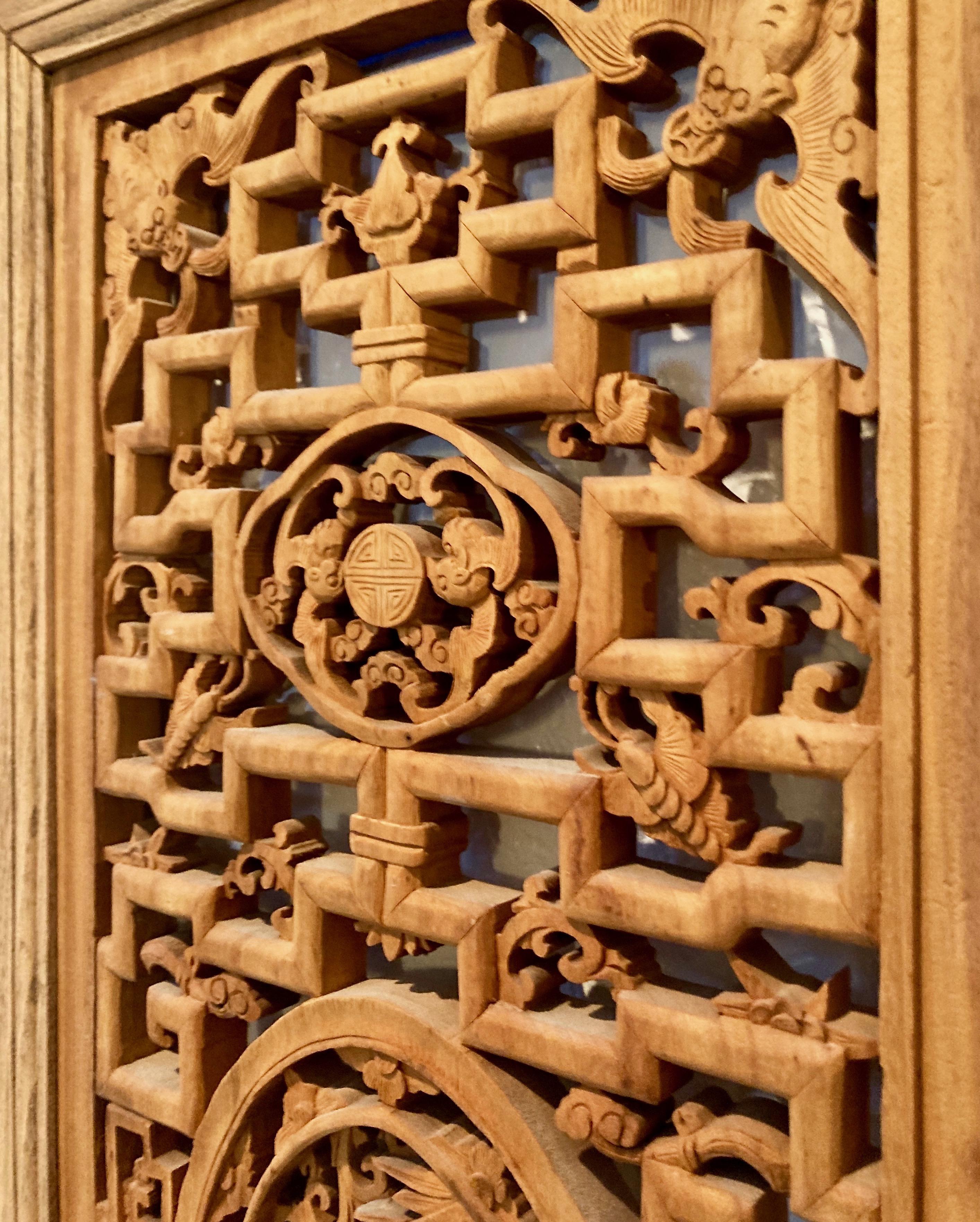 The intricate design in this framed panel includes an oval center carving with a bird and floral motif, and a surrounding bat motif.