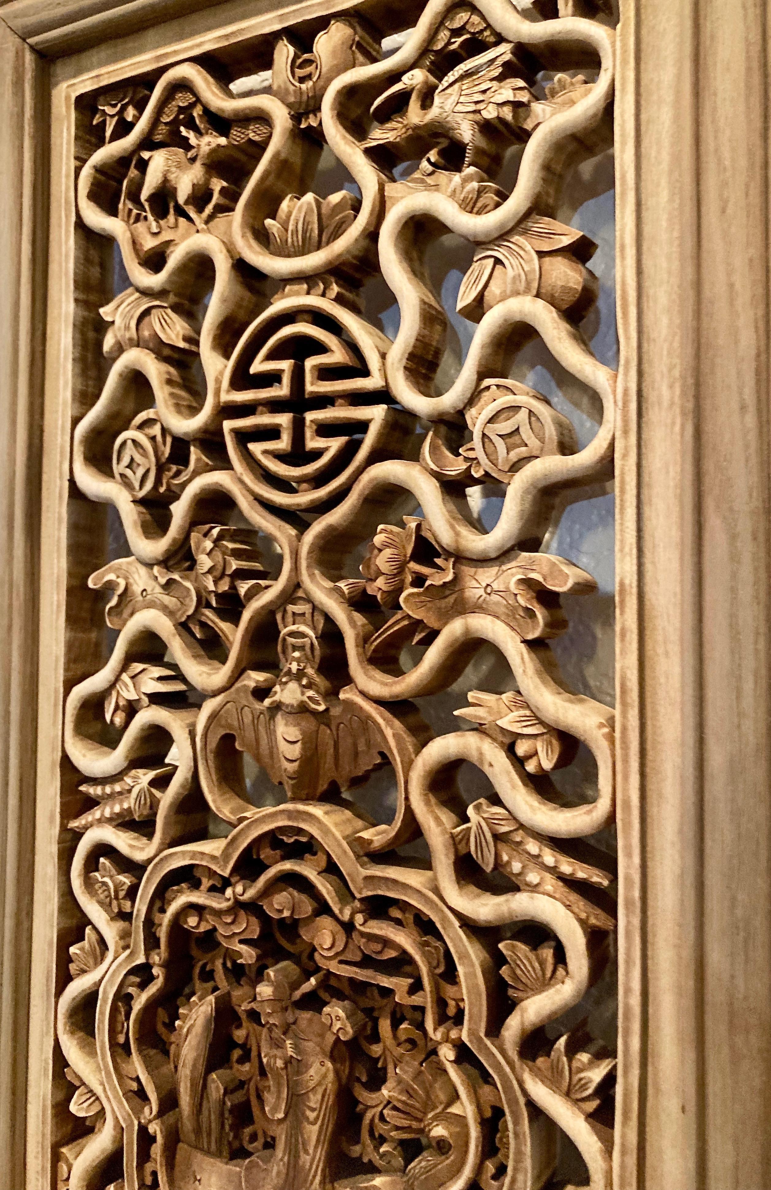 This ornately designed framed panel includes a plum blossom shaped center carving with personage, and surrounding geometric patterns, bat and creature motifs.