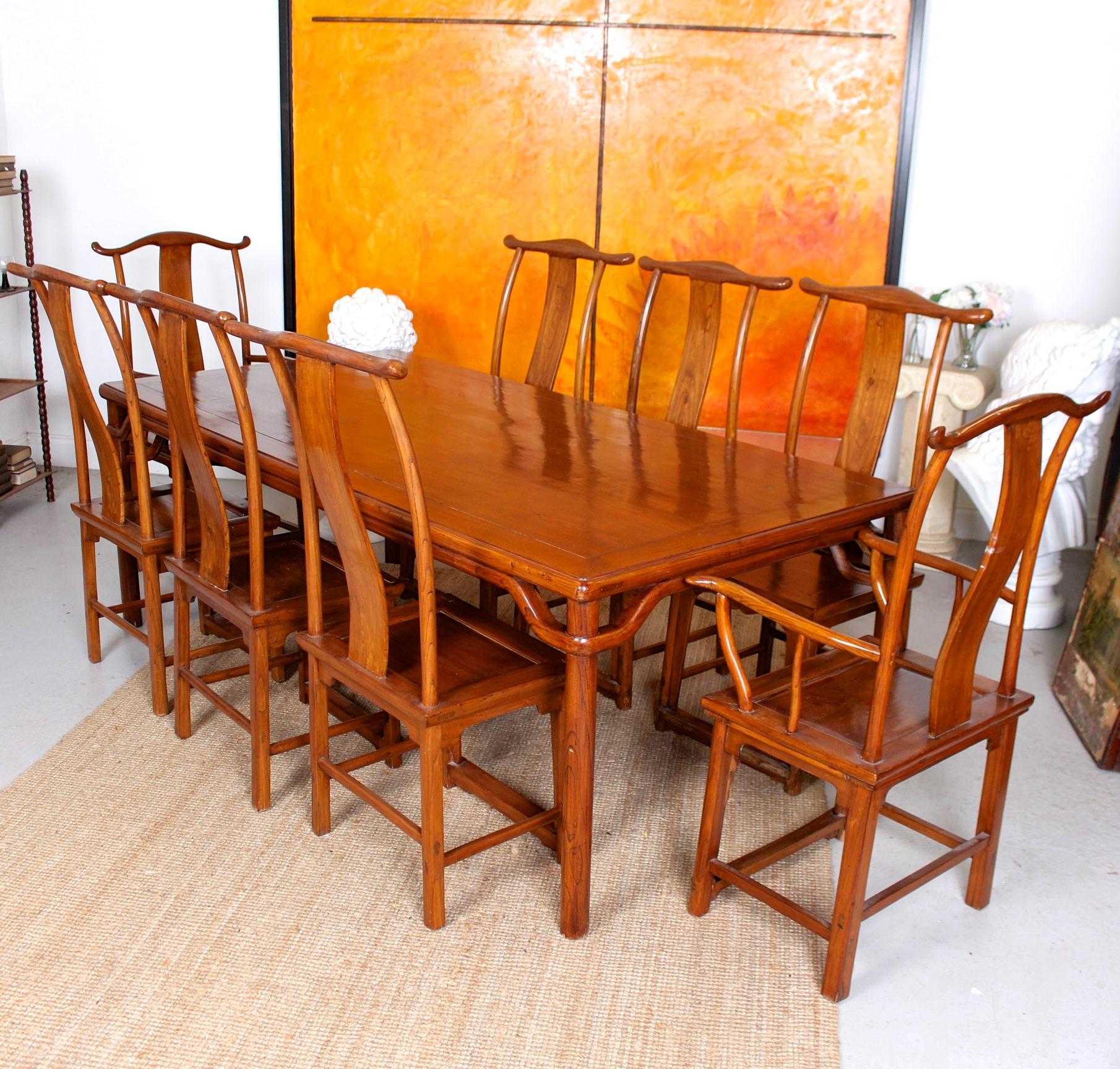 An impressive fine quality nine-piece mahogany Chinese dining suite.

The Chinese hardwood boasting a rich polished patina.

The table with shaped edges raised on carved rounded legs.
The chairs with carved and shaped backrests on solid