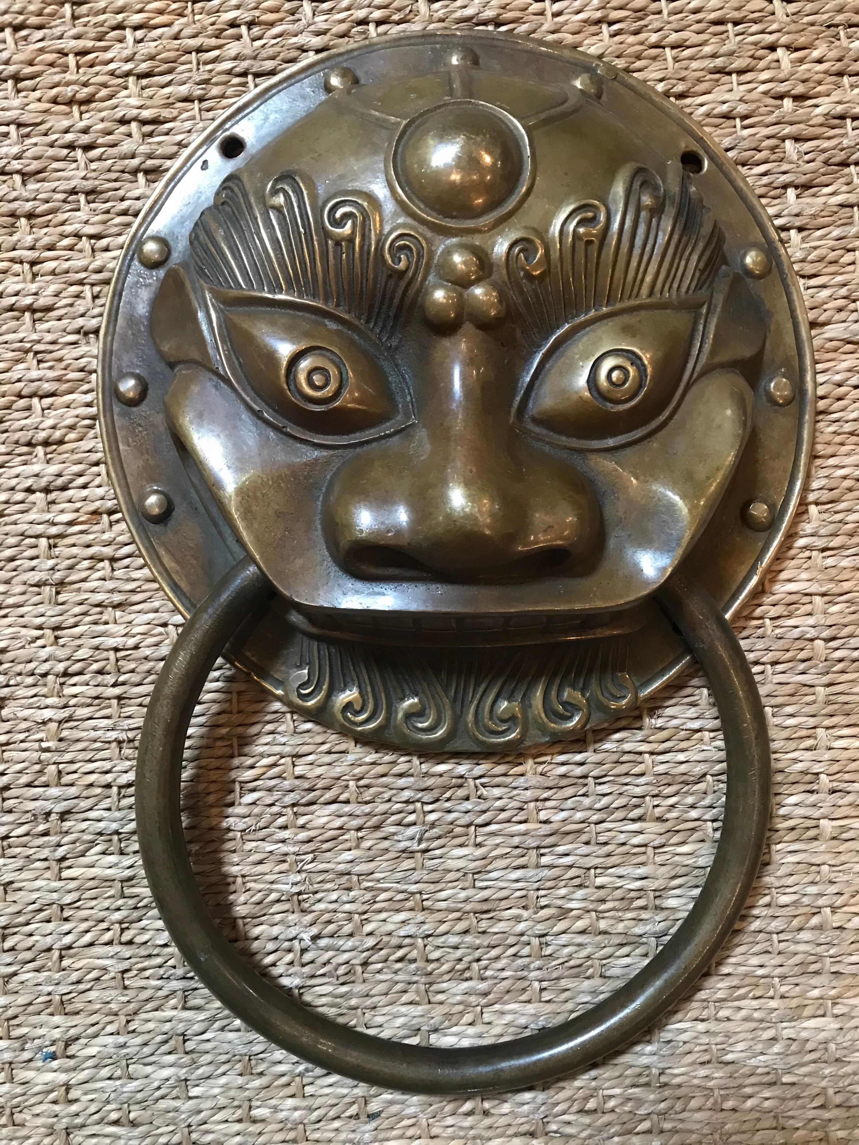 These vintage Chinese door pulls are from the first quarter of the 20th century. They feature a traditional Chinese dragon style face with a hoop door pull extending from the wide mouth.