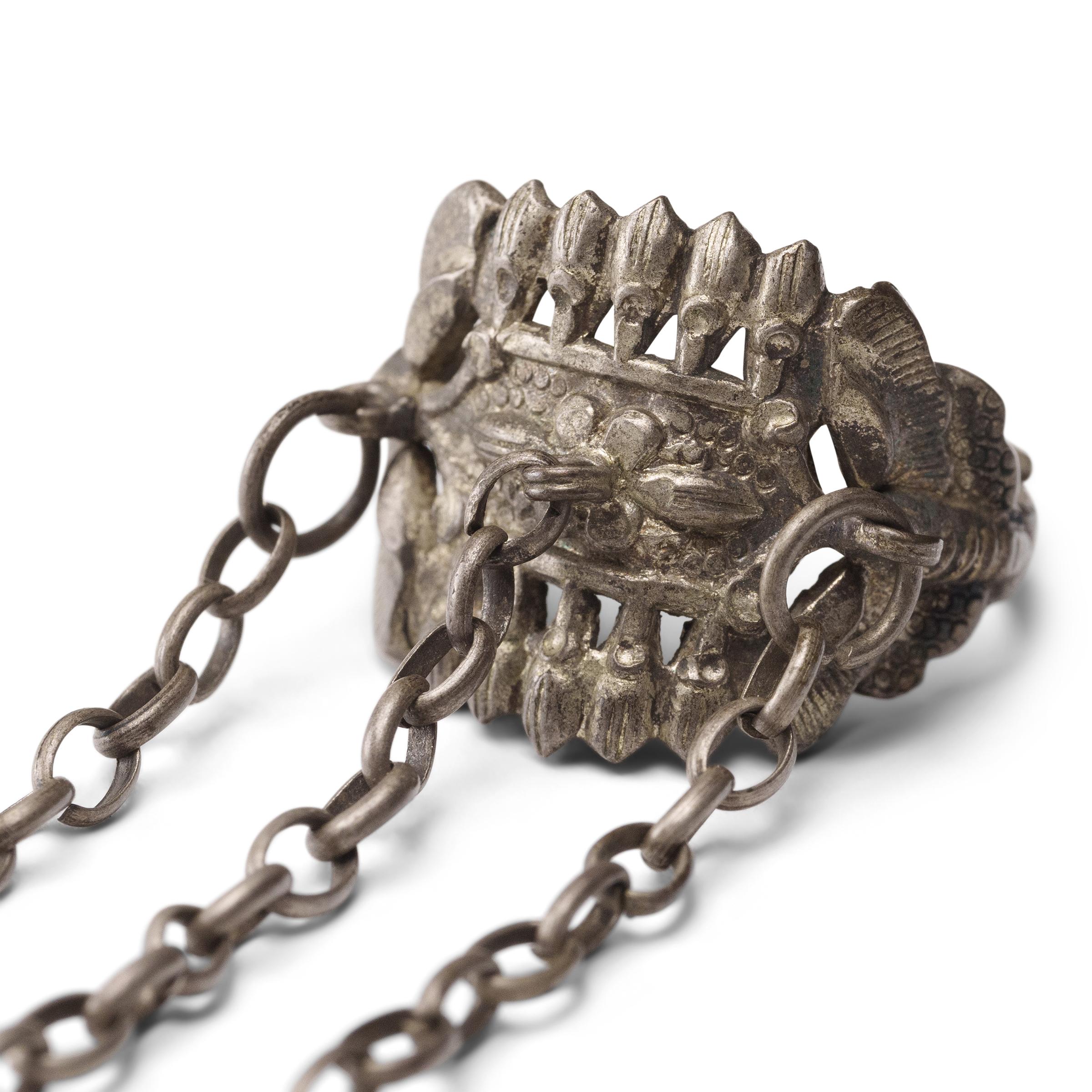 Dated to the late 19th century, this silver charm ring was crafted by the Miao peoples of the Guizhou province and was believed to protect the wearer from bad luck and malevolent spirits. The ring is decorated in low relief with five-petal flowers