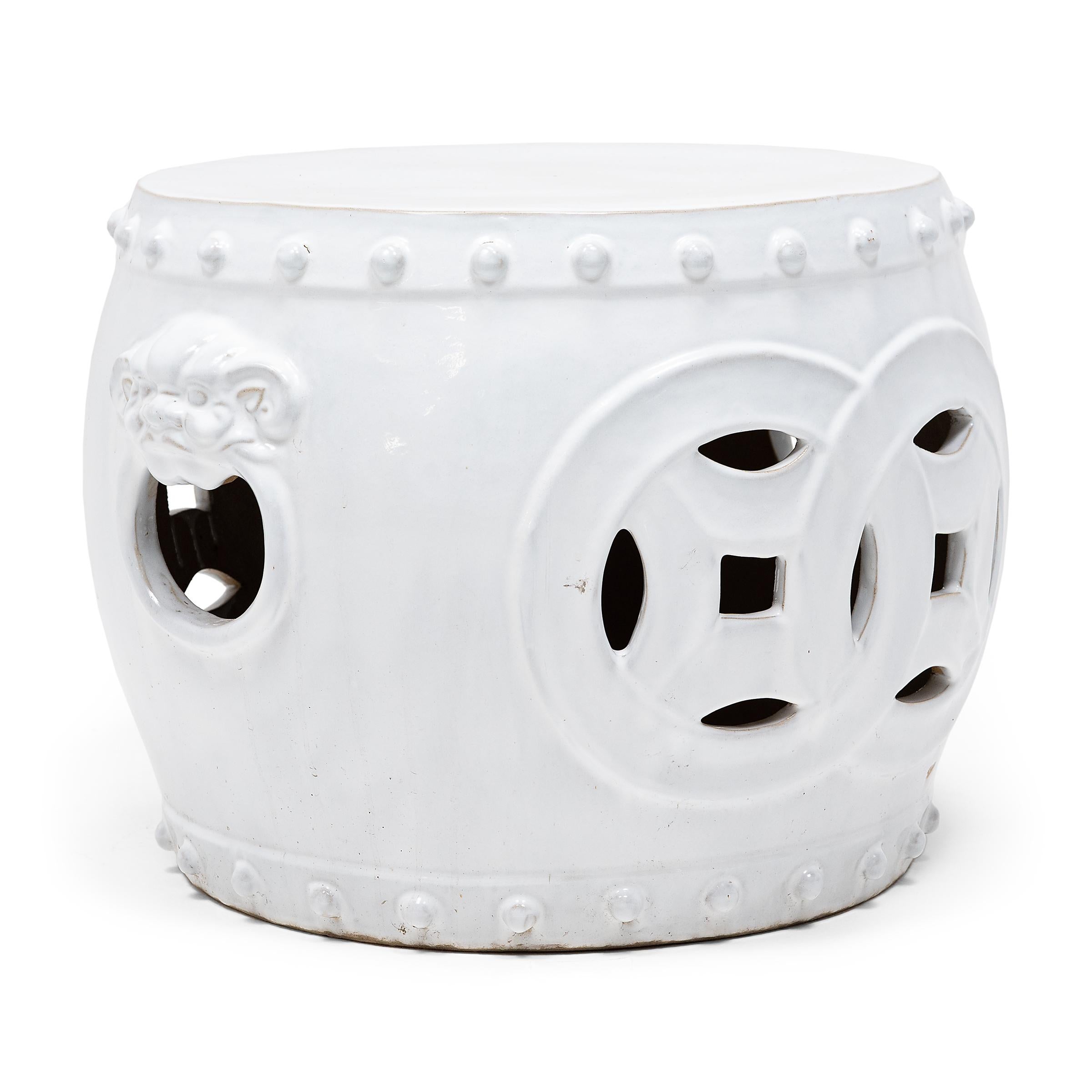 This unusually proportioned ceramic table is a modern interpretation of the classic Chinese drum-form garden stool. Cloaked in a pristine, monochrome white glaze, the wide stool is decorated with bands of imitation nails, fu dog handles, and a