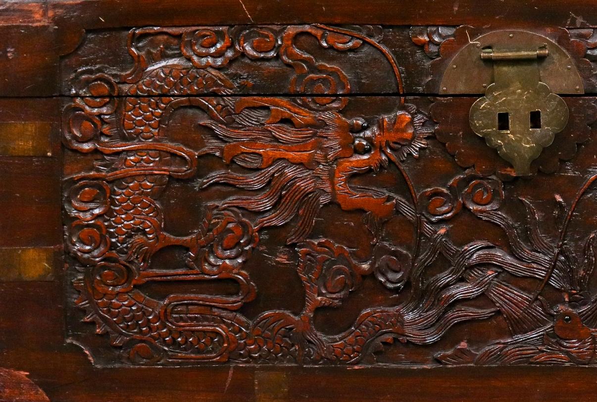 Chinese carved wood trunk chest, the hinged lid and front with elaborate dragon carving, metal lock and handles to sides, marked to interior: 