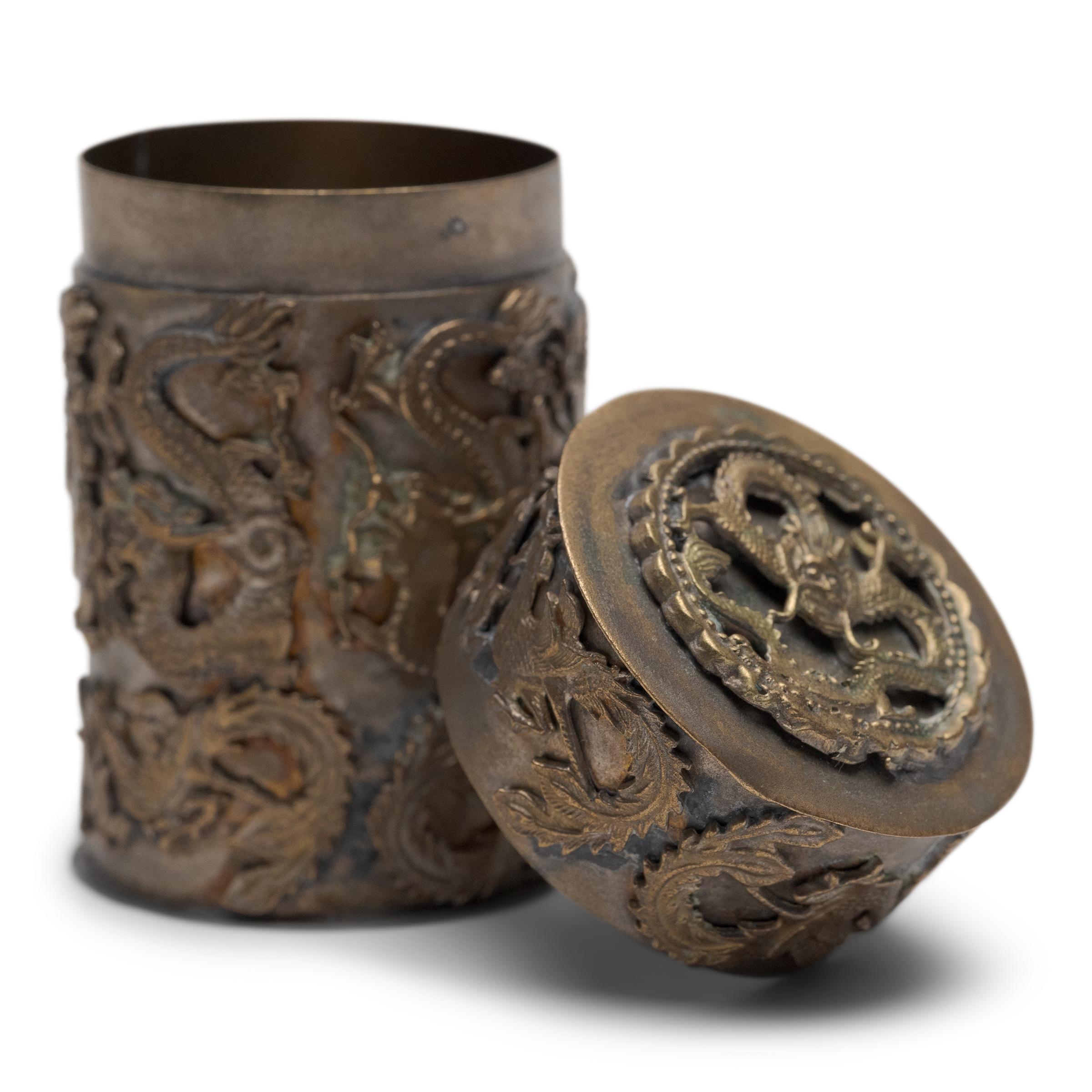 This petite metal box recreates the canisters once used to store a smoker's personal supply of opium paste. The box is decorated with relief casts of dragons and phoenixes, symbols of success and marital harmony.
