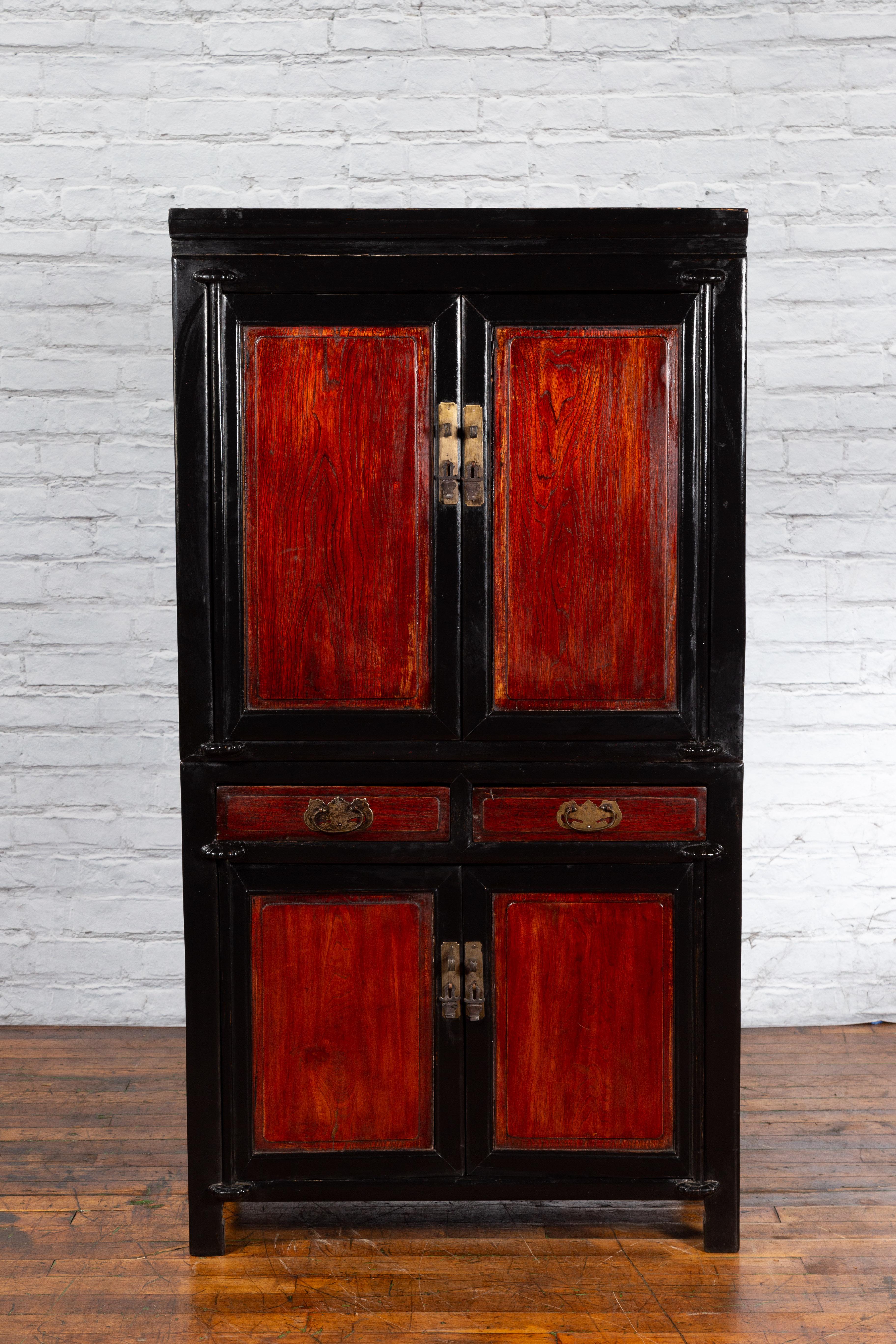 A Chinese black and brown lacquered cabinet from the early 20th century, with with brass hardware, four doors and drawers. Created in China during the early years of the 20th century, this cabinet features a linear silhouette made of a black body