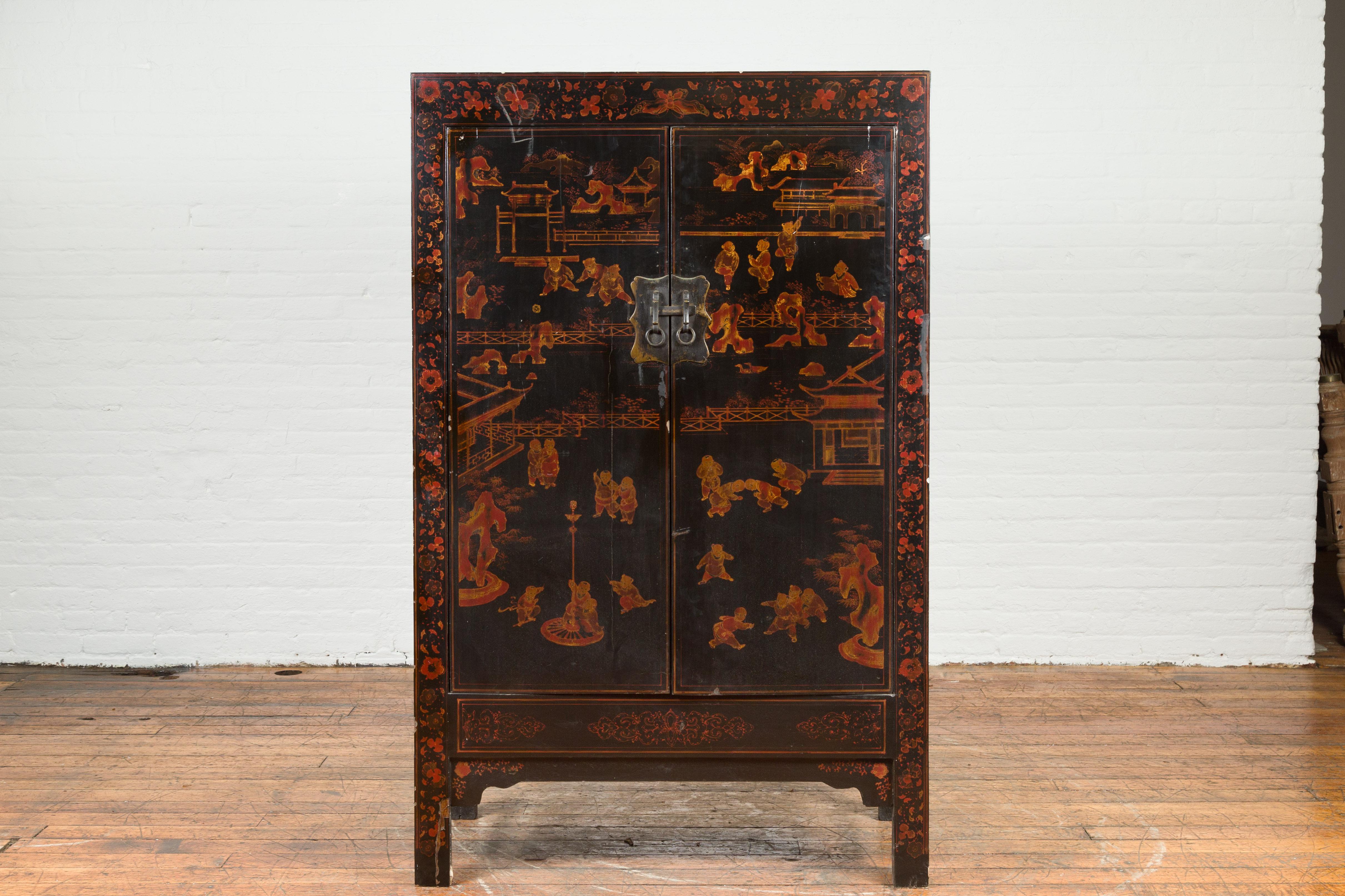 A Chinese black lacquer cabinet from the early 20th century, with Chinoiserie décor. Created in China during the early years of the 20th century, this black lacquer cabinet features a Chinoiserie décor adorning two doors fitted with scalloped brass