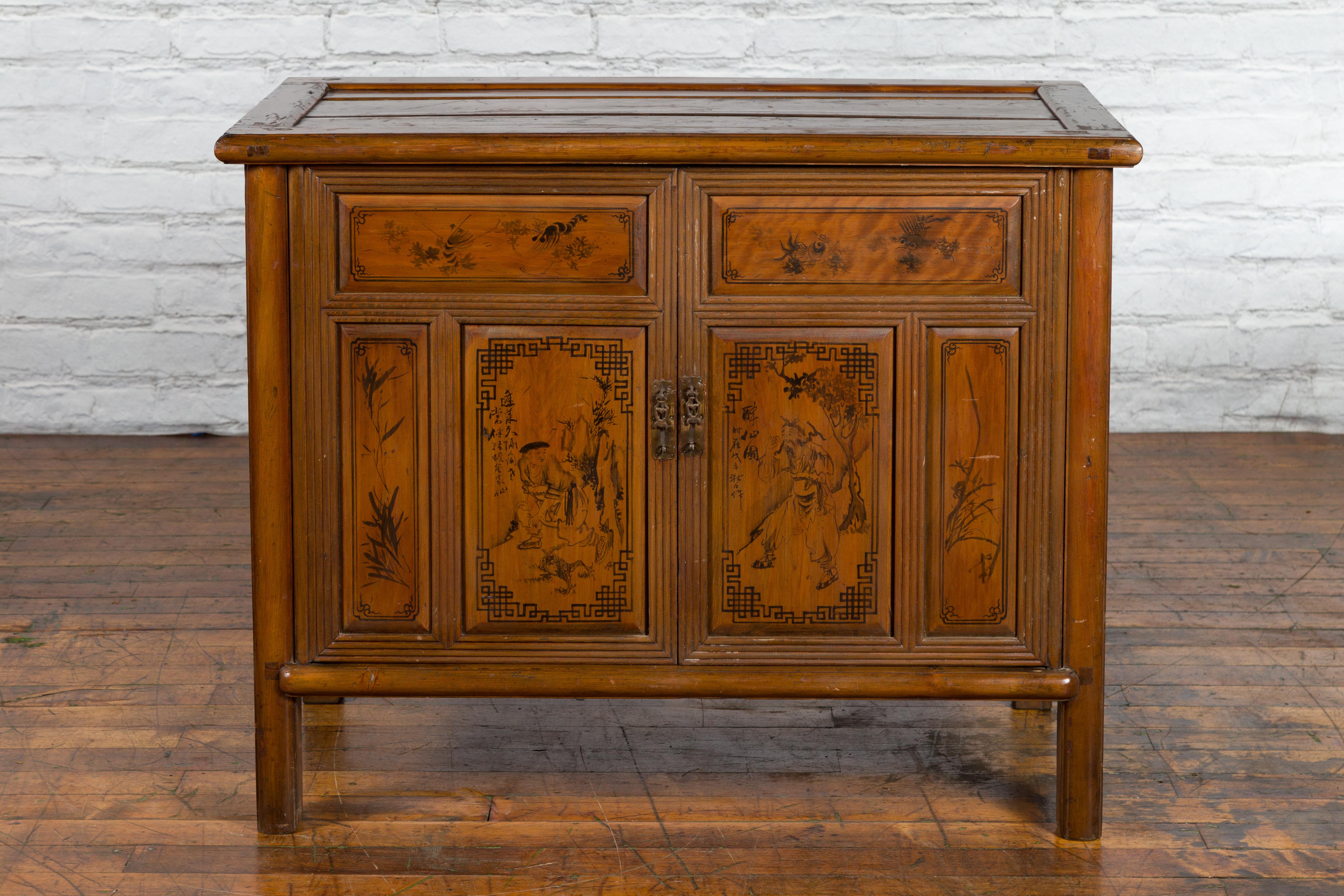 A Chinese antique cabinet from the early 20th century, with hand-painted décor and hidden double drawers. Created in China during the early years of the 20th century, this wooden cabinet features a rectangular top with recessed panel, sitting above