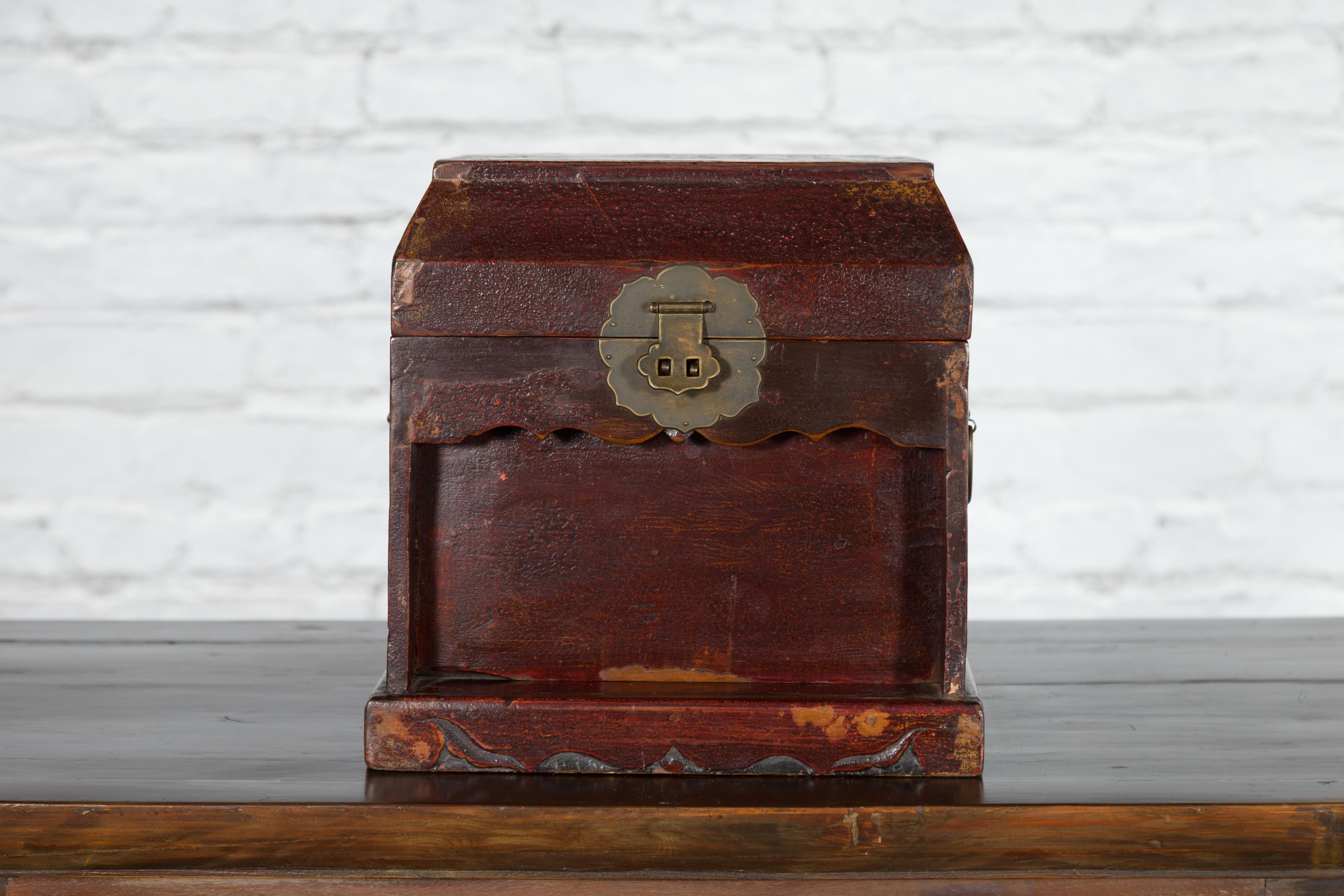 An antique Chinese document box from the early 20th century with dark red distressed lacquer and brass hardware. Created in China during the early years of the 20th century, this document box features a rectangular tapering lid with nicely