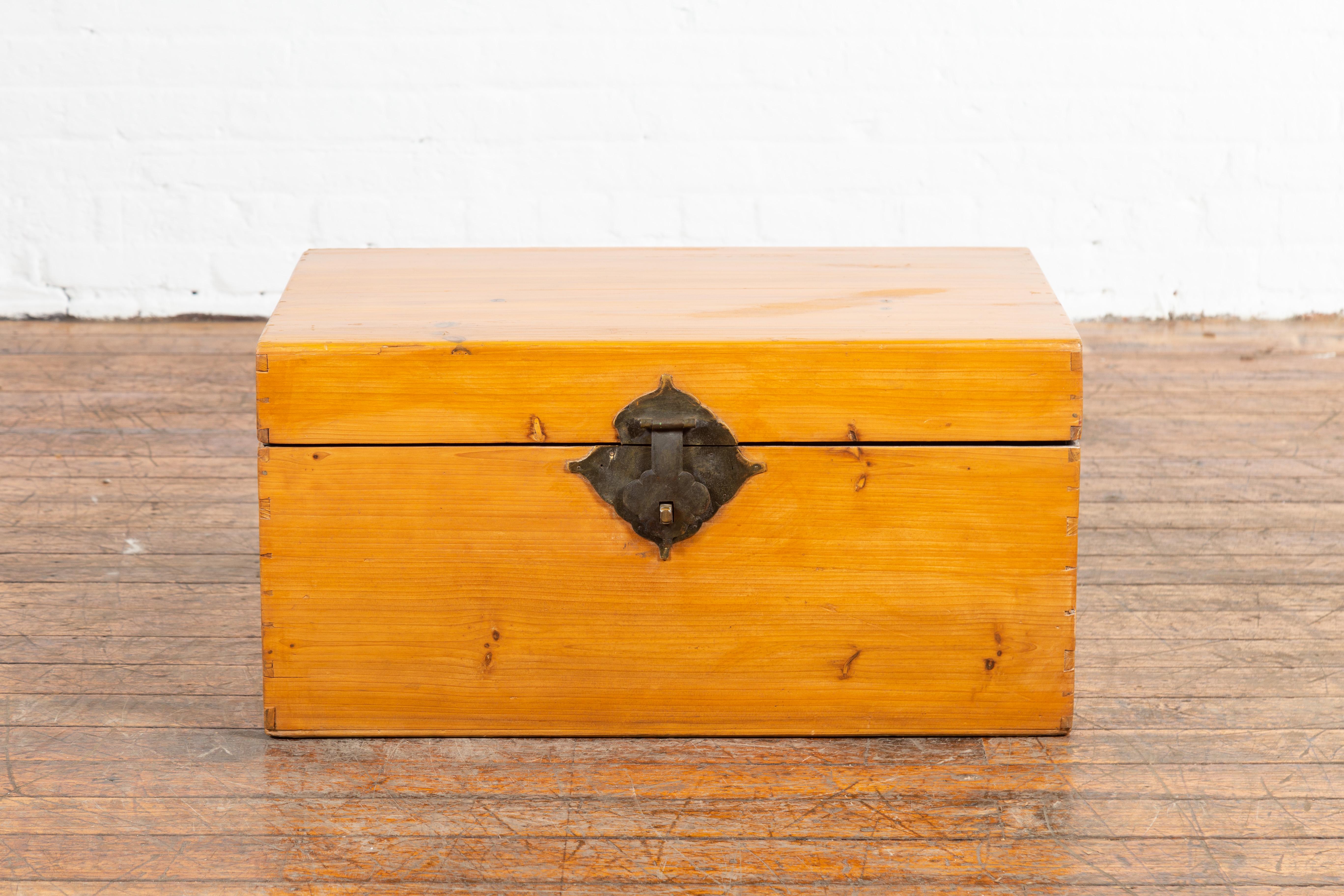 A Chinese elmwood blanket chest from the early 20th century, with lateral handles. Created in China during the early years of the 20th century, this elm blanket chest features a linear silhouette perfectly complimented by a honey toned patina. The