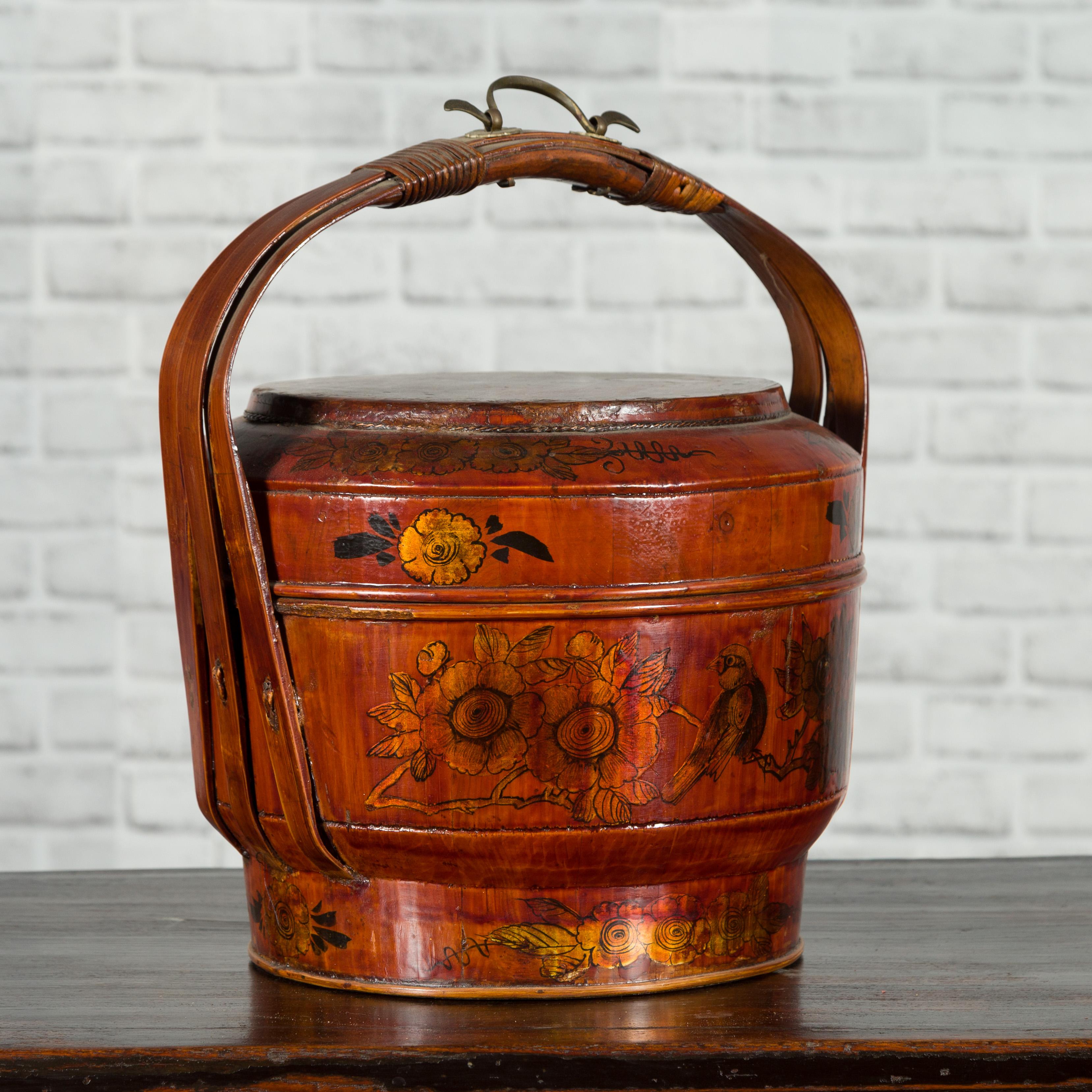 A Chinese picnic basket from the early 20th century, with large handle and painted motifs. Created in China during the early years of the 20th century, this picnic basket features a lacquered body adorned with painted motifs depicting showcasing